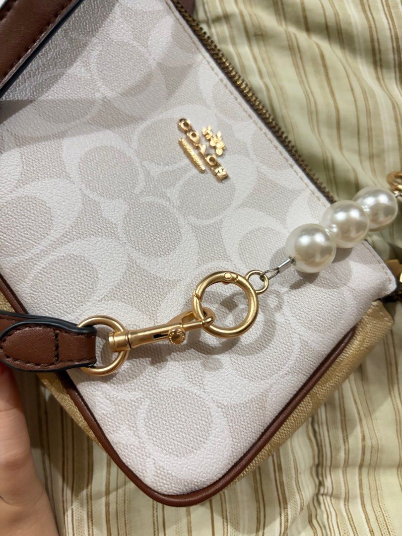 Coach Signature Bag (Category: Luxury Bags & Wallets) located in Manila. Submitted by cococlutters (Listing ID 1413320308, Image 2). Description: NEGOTIABLE‼️ Made in vietnam - Coach signature bag - | No issue - Brown leather strap - Zip closure - Gold-toned hardware - White and beige pattern with brown trim - Compact size - Ideal for carrying essentials.