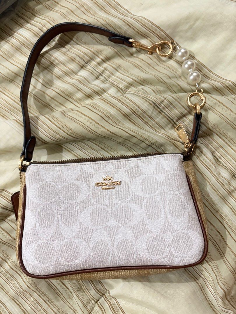 Coach Signature Bag (Category: Luxury Bags & Wallets) located in Manila. Submitted by cococlutters (Listing ID 1413320308, Image 3). Description: NEGOTIABLE‼️ Made in vietnam - Coach signature bag - | No issue - Brown leather strap - Zip closure - Gold-toned hardware - White and beige pattern with brown trim - Compact size - Ideal for carrying essentials.