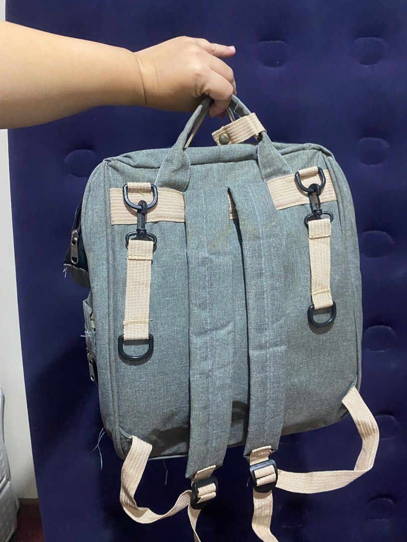 Grey Baby Bag (Category: Diaper Bags & Wetbags) located in Binan City. Submitted by lagunaxpreloved (Listing ID 1416643790, Image 2). Description: - Grey diaper backpack - Multiple compartments and pockets for organization - Top handle and adjustable straps - Front and side pockets - Stroller straps on the back - Features a "YOU ARE MY SUNSHINE" label.