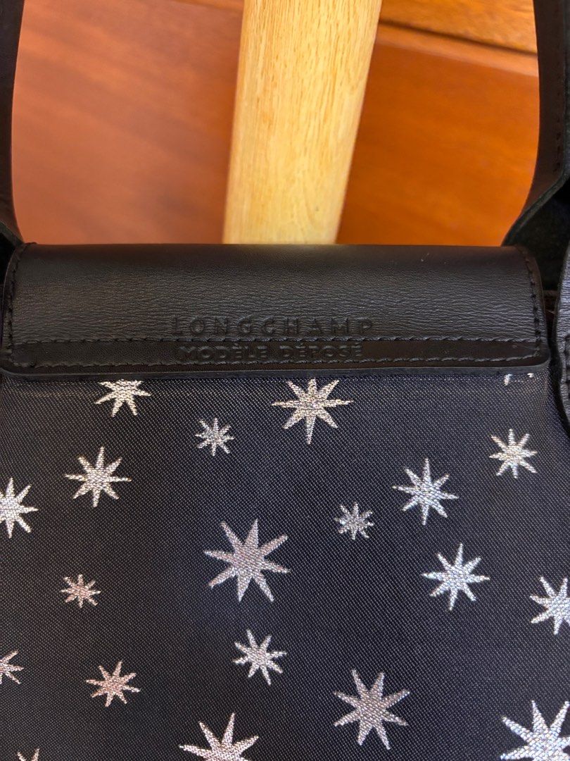 Longchamp Le Pliage Etoiles Top-Handle Bag S (Category: Luxury Bags & Wallets) located in Quezon City. Submitted by onlinebazaare (Listing ID 1416816351, Image 3). Description: - Longchamp Le Pliage Etoiles Top-Handle Bag S -bought directly from Rustans on sale for 12k - Navy blue fabric with star pattern - Black leather handles and flap - Detachable shoulder strap - Silver-toned hardware - Zipper closure - Matching fabric lining.