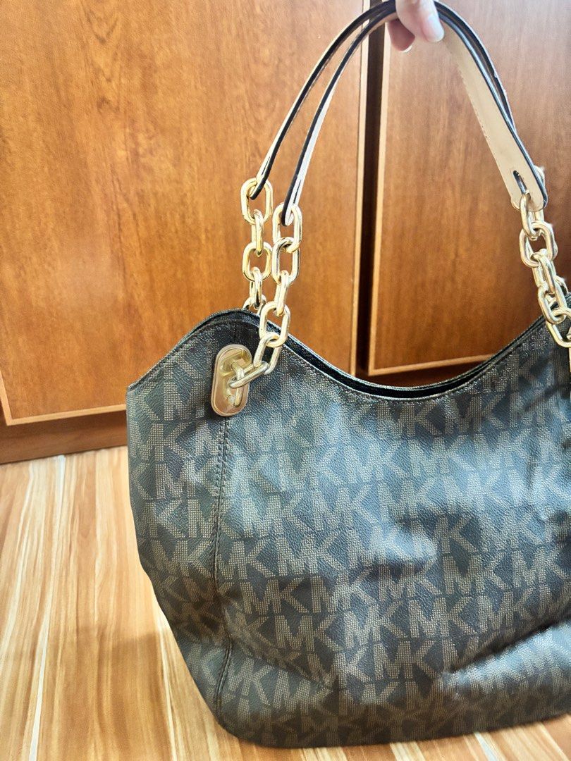 Michael Kors Authentic Monogram Tote Handbag Bag (Category: Luxury Bags & Wallets) located in Angeles City. Submitted by rawd3nim (Listing ID 1416271132, Image 2). Description: - Authentic Michael Kors handbag, a hand me down from my mom. - Features the iconic MK logo pattern - Comes with a detachable charm - Stylish chain strap - Elegant brown leather exterior - Luxurious gold-tone hardware - Light beige interior lining .