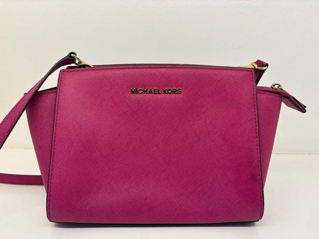 Michael Kors Selma Messenger Bag (Category: Luxury Bags & Wallets) located in Makati City. Submitted by harekrisha (Listing ID 1416668781, Image 1). Description: Pre-loved Michael Kors Selma messenger bag in fuchsia saffiano leather. Structured and sturdy, with a zip closure, interior compartments, and classic Michael Kors hardware and logo details. In good pre-loved condition with normal signs of use from regular wear. No major flaws and still v