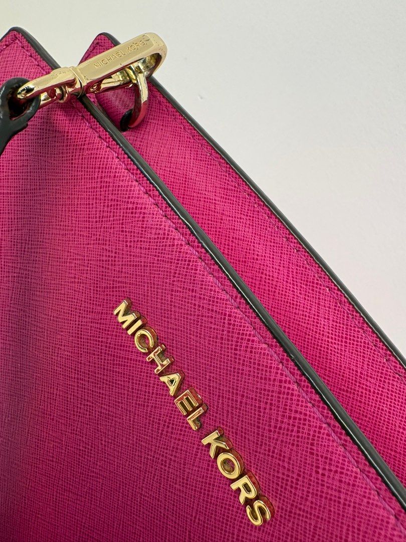 Michael Kors Selma Messenger Bag (Category: Luxury Bags & Wallets) located in Makati City. Submitted by harekrisha (Listing ID 1416668781, Image 3). Description: Pre-loved Michael Kors Selma messenger bag in fuchsia saffiano leather. Structured and sturdy, with a zip closure, interior compartments, and classic Michael Kors hardware and logo details. In good pre-loved condition with normal signs of use from regular wear. No major flaws and still v