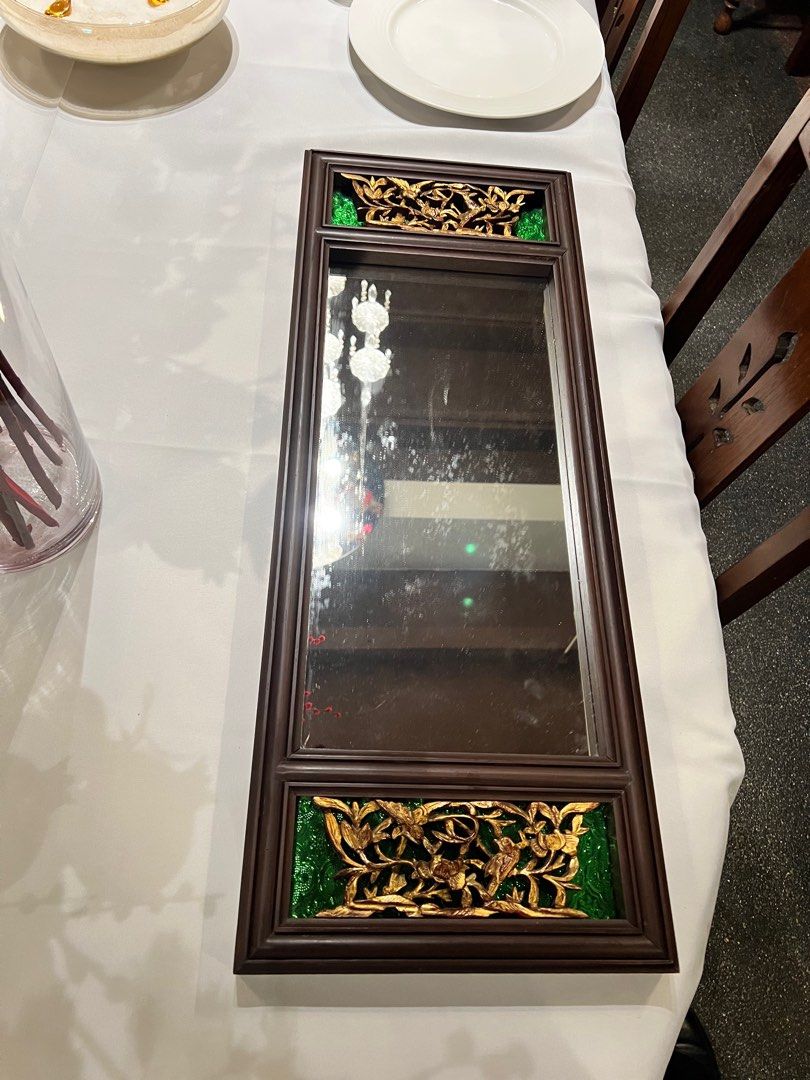 Mirror (Category: Mirrors) located in Singapore. Submitted by fastdeer_070b1c (Listing ID 1416688607, Image 1). Description: Elegant wall mirror with a classic wooden frame and ornate floral carvings on both ends (green accent panels). Great as a statement piece for living room, dining area, hallway, or bedroom. Can be mounted vertically (as shown) or horizontally depending on your space. • Size: 77 x 30 cm (approx.) .