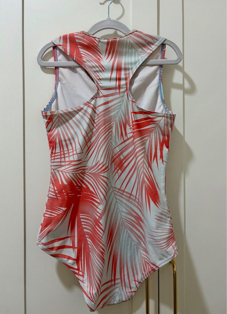 One-Piece Swimsuit with Palm Print (Category: Bikinis & Swimsuits) located in Quezon City. Submitted by jamieeelaaa (Listing ID 1416685900, Image 2). Description: - One-piece swimsuit with a colorful palm leaf print (red and white). - Zip-up front and racerback design. - Sleeveless with a scoop neckline. - Made from a stretchy material for a comfortable fit. - Features a light blue trim on the bottom. - Safe for surfing and snorkeling..