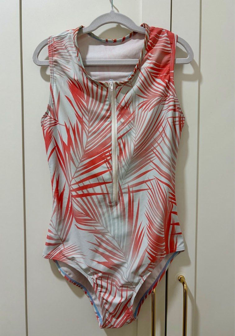 One-Piece Swimsuit with Palm Print (Category: Bikinis & Swimsuits) located in Quezon City. Submitted by jamieeelaaa (Listing ID 1416685900, Image 1). Description: - One-piece swimsuit with a colorful palm leaf print (red and white). - Zip-up front and racerback design. - Sleeveless with a scoop neckline. - Made from a stretchy material for a comfortable fit. - Features a light blue trim on the bottom. - Safe for surfing and snorkeling..