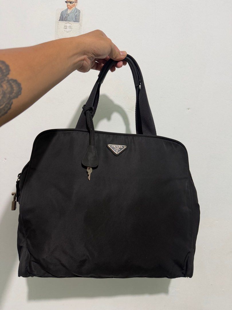 Prada Black Nylon Tote Bag (Category: Luxury Bags & Wallets) located in Sorsogon. Submitted by jovert_23alviz (Listing ID 1416742835, Image 1). Description: - Authentic Prada tote bag - Color: Black - Features: Lock and key, Prada logo - Closure: Top zipper - Lining: Fabric - Interior: Prada Milano Made in Italy tag - Handle drop - Bottom base with metal studs.