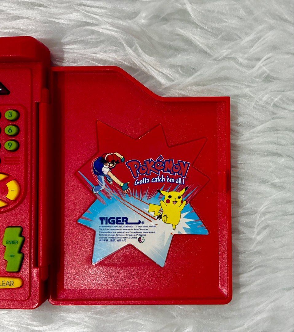 Preloved Original Pokemon Pokedex by Tiger (Category: Character Goods) located in Quezon City. Submitted by greatgoodies03 (Listing ID 1416745590, Image 3). Description: - Preloved Original Pokemon Pokedex by Tiger - Classic red design - Features the iconic Pokemon logo and characters - Fully functional screen and buttons - A great addition to any Pokemon collection - Perfect for fans of all ages ** ISSUE upper left side screen dead pixel see pho