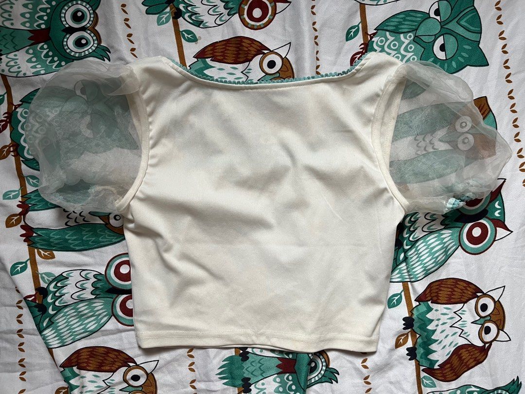 White Puff Sleeve Top with Blue Trim (Category: Sleeveless) located in Paranaque City. Submitted by rieclutter (Listing ID 1416739690, Image 2). Description: - Square neckline - Delicate blue trim - Small blue rose detail - Sheer overlay on sleeves and neckline - Smooth, synthetic fabric - Classic design - Timeless piece - Fits xs-s.