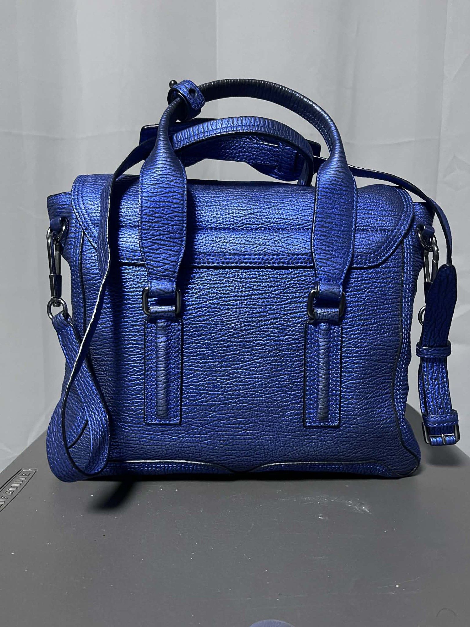 3.1 Phillip Lim Pashli Medium Satchel Bag (Category: Luxury Bags & Wallets) located in Quezon City. Submitted by carmeladelacruz82 (Listing ID 1416953233, Image 2). Description: - AUTHENTIC Phillip Lim Pashli Medium Satchel Bag - Color: Metallic Blue - Material: Leather - Complete with DUST BAG and PAPERS - Condition: No major flaws; can even pass as “like new”. Meron lang slight discoloration sa ilalim ng handle but barely noticeable (see last p