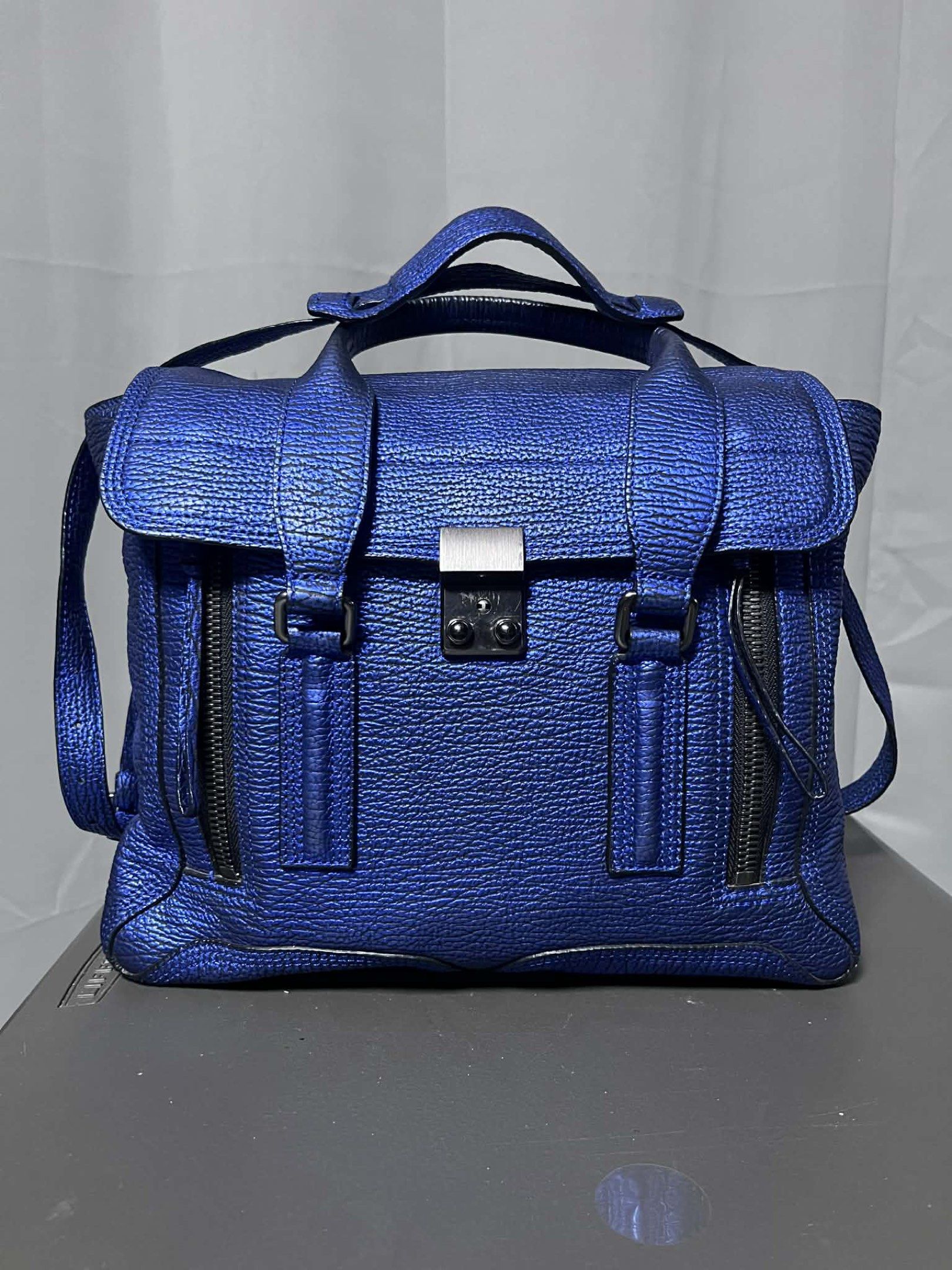 3.1 Phillip Lim Pashli Medium Satchel Bag (Category: Luxury Bags & Wallets) located in Quezon City. Submitted by carmeladelacruz82 (Listing ID 1416953233, Image 1). Description: - AUTHENTIC Phillip Lim Pashli Medium Satchel Bag - Color: Metallic Blue - Material: Leather - Complete with DUST BAG and PAPERS - Condition: No major flaws; can even pass as “like new”. Meron lang slight discoloration sa ilalim ng handle but barely noticeable (see last p