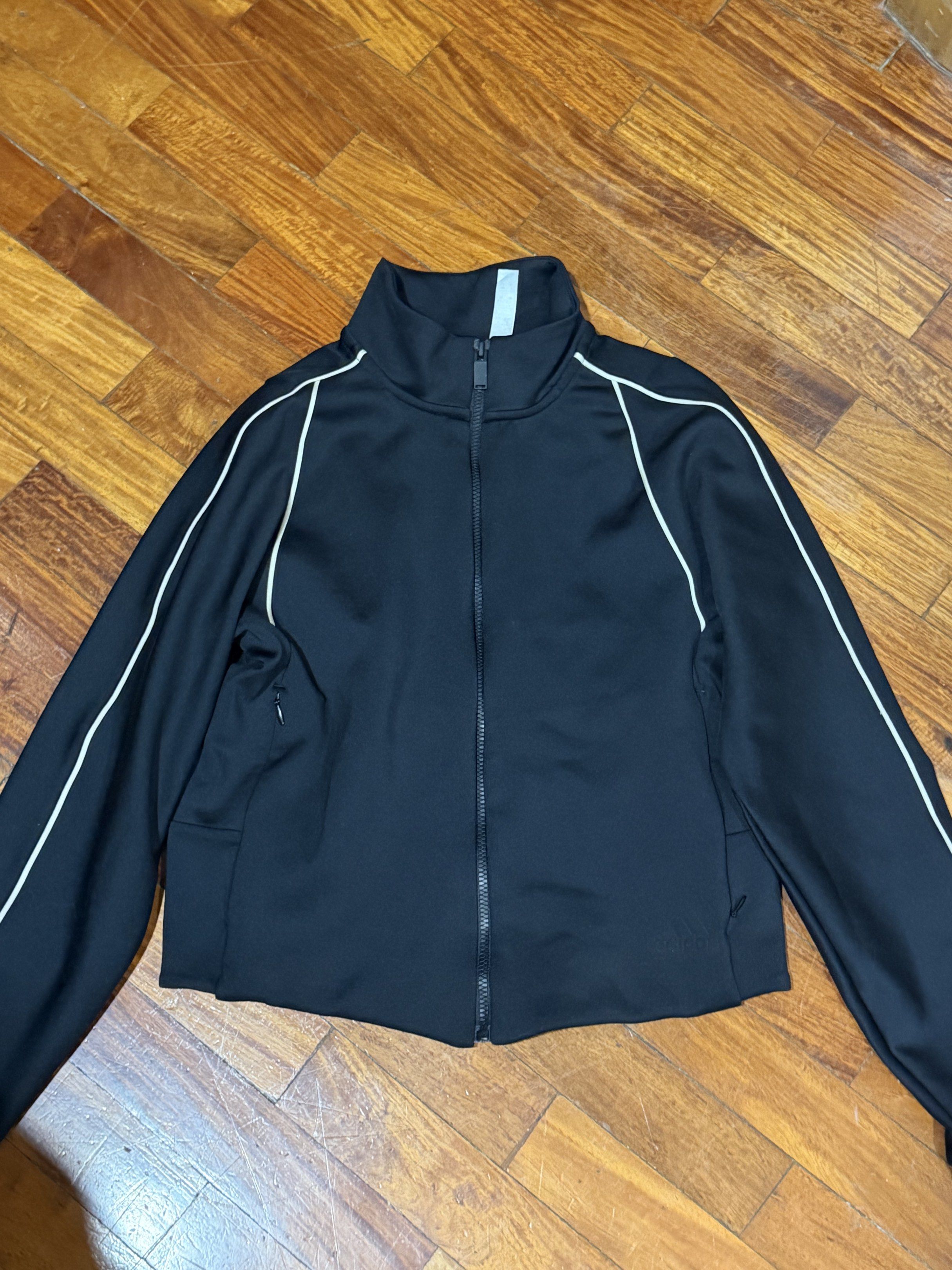 Adidas Black Track Jacket with White Piping (Category: Coats, Jackets and Outerwear) located in Del Monte. Submitted by bren.lim (Listing ID 1416978684, Image 1). Description: - Black track jacket - White piping details - Full-length zipper - Stand-up collar - Long sleeves - Sporty design - Smooth, athletic material.