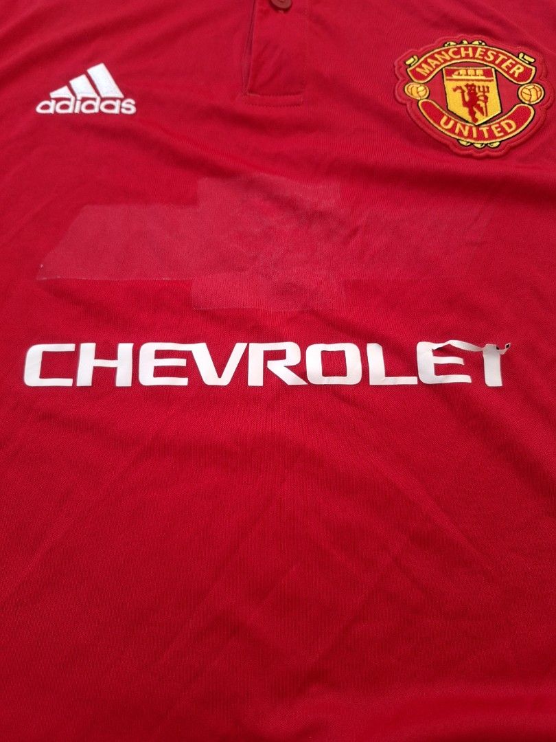 Adidas Manchester United Jersey (Category: Activewear) located in Marikina City. Submitted by 2nd_chancedrips (Listing ID 1416932836, Image 3). Description: Official Manchester United jersey in red with the Chevrolet logo. Features the Adidas logo and three stripes on the shoulders. The jersey has a collared neckline with two buttons. The tag indicates it is a Climacool jersey. Authentic m on tag 20 x 28 excellent condition embroidered logo issue