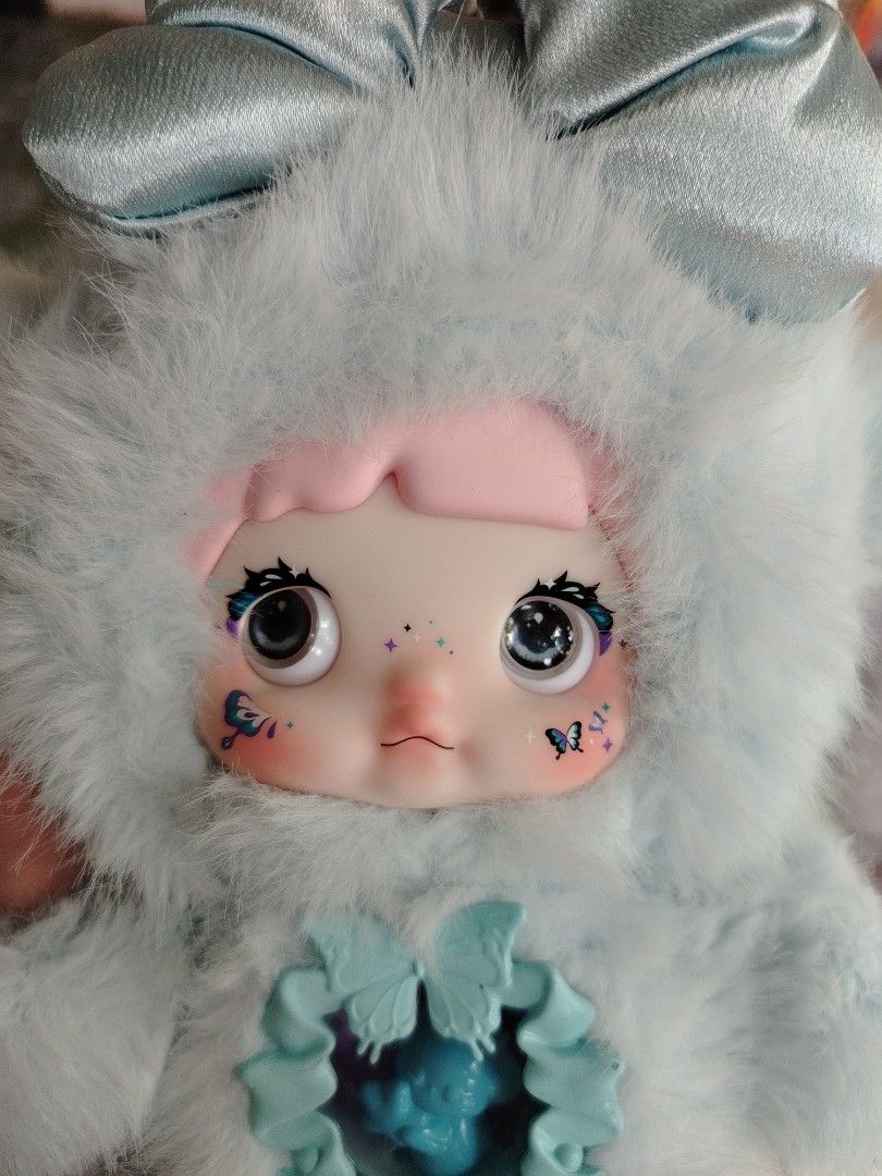 Art Doll with Bunny Outfit (Category: Plushies & Soft Toys) located in Tayasan. Submitted by _raceprettyconcept (Listing ID 1416873491, Image 2). Description: - Art doll in a unique bunny outfit - Soft, fluffy blue and white material - Detailed painted face - Butterfly design accents - Decorative chest piece with butterfly - Visible ears and paws.