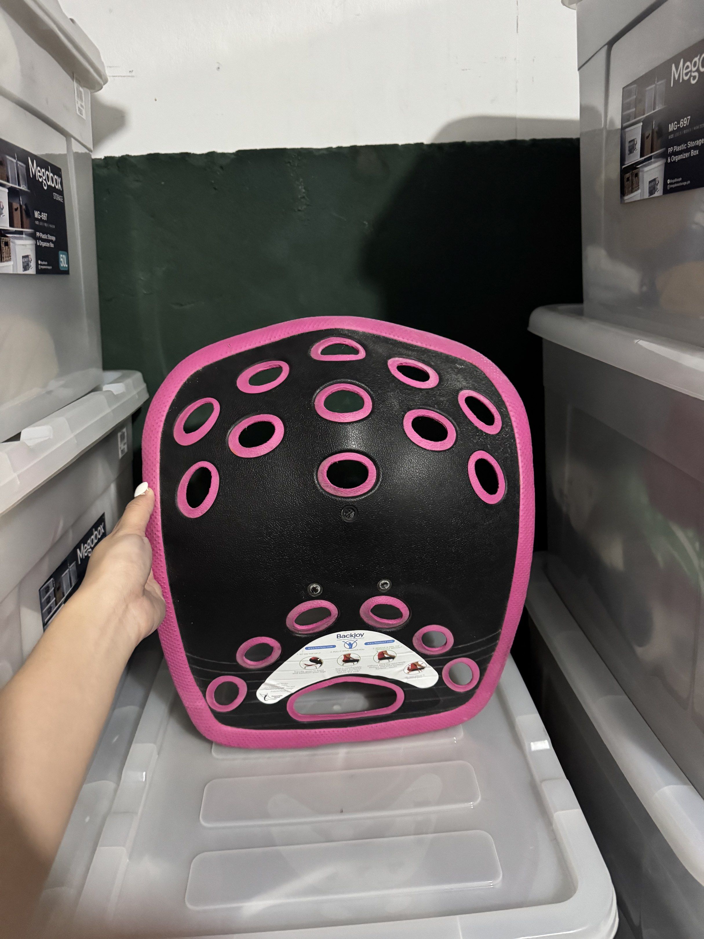 BackJoy Posture Support (Category: Braces, Support & Protection) located in Quezon City. Submitted by myprelauved (Listing ID 1416989805, Image 3). Description: - BackJoy posture support - Pink and black design - Improves posture while sitting - Features ventilation holes - Curved shape for support - Includes a handle for easy carrying - BackJoy logo visible.