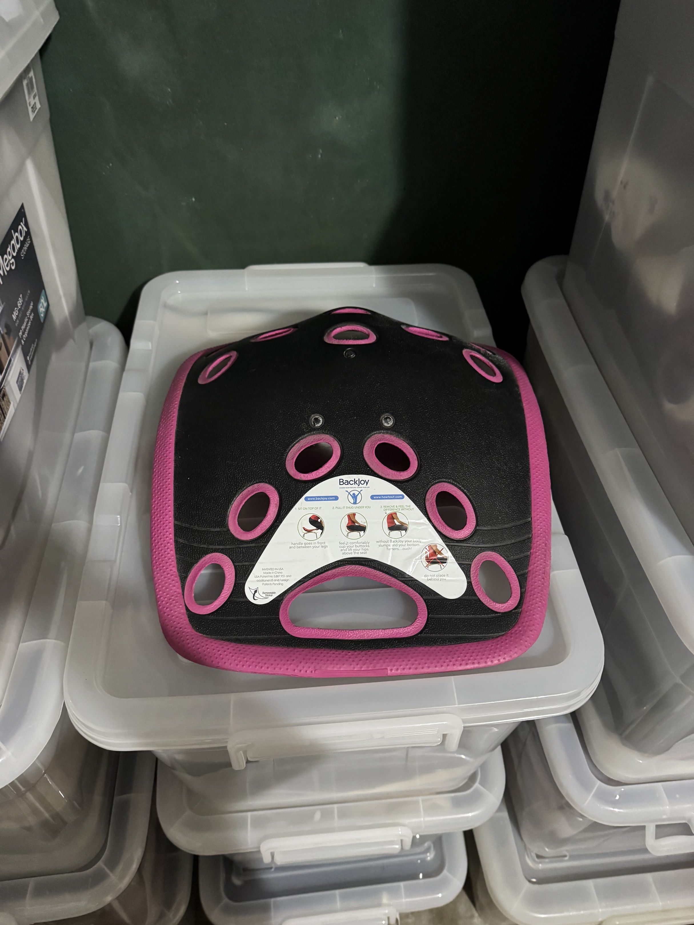 BackJoy Posture Support (Category: Braces, Support & Protection) located in Quezon City. Submitted by myprelauved (Listing ID 1416989805, Image 2). Description: - BackJoy posture support - Pink and black design - Improves posture while sitting - Features ventilation holes - Curved shape for support - Includes a handle for easy carrying - BackJoy logo visible.