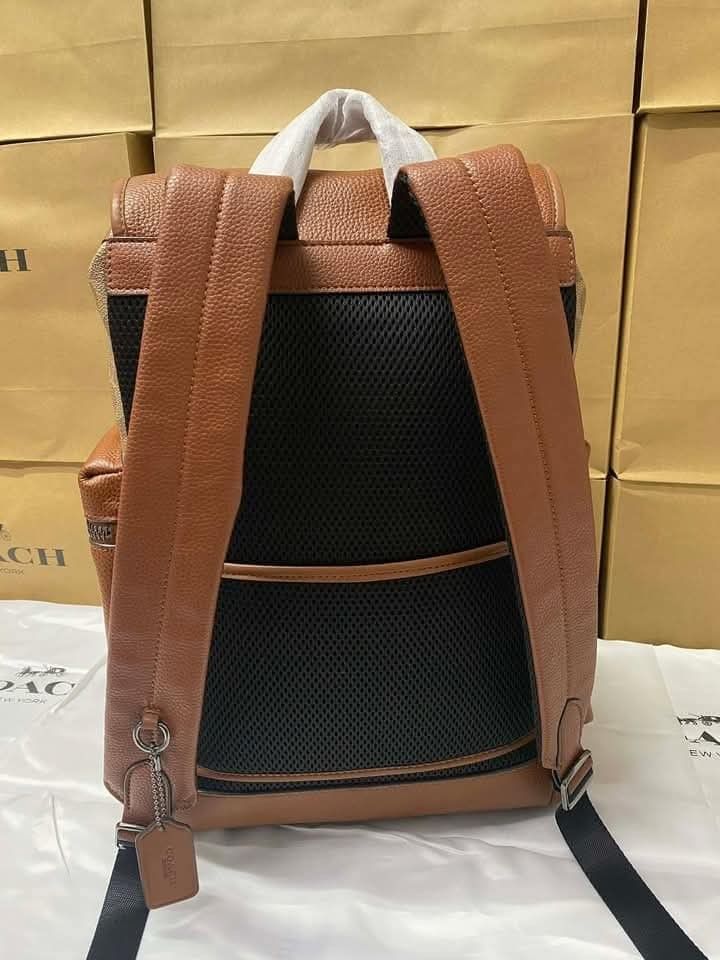 Coach Snoopy Patchwork Backpack (Category: Luxury Bags & Wallets) located in Manila. Submitted by santosrich_419 (Listing ID 1416998724, Image 3). Description: Coach backpack features a brown leather and signature canvas design with Snoopy patches. It has multiple pockets, including a front zippered pocket and side pockets. The backpack has adjustable straps and a drawstring closure. Dimensions are approximately 42x30cm..
