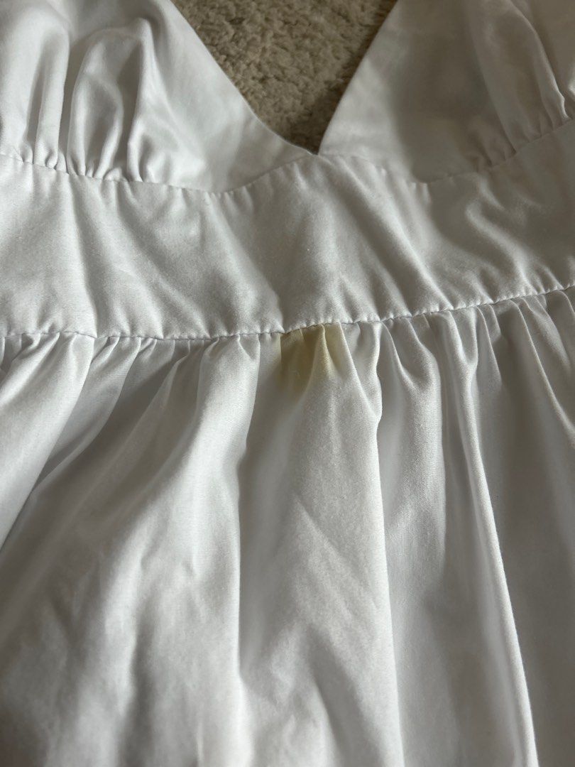 Love, Ara White Dress - Small (Category: Dresses) located in Taguig. Submitted by rcdeclutter (Listing ID 1416905711, Image 3). Description: - Brand: Love, Ara - Style: White dress - Features: V-neckline, adjustable spaghetti straps, fitted bodice, flowing skirt with ruffled hem and eyelet detailing - Size: Small - Condition: Visible stains on the front.
