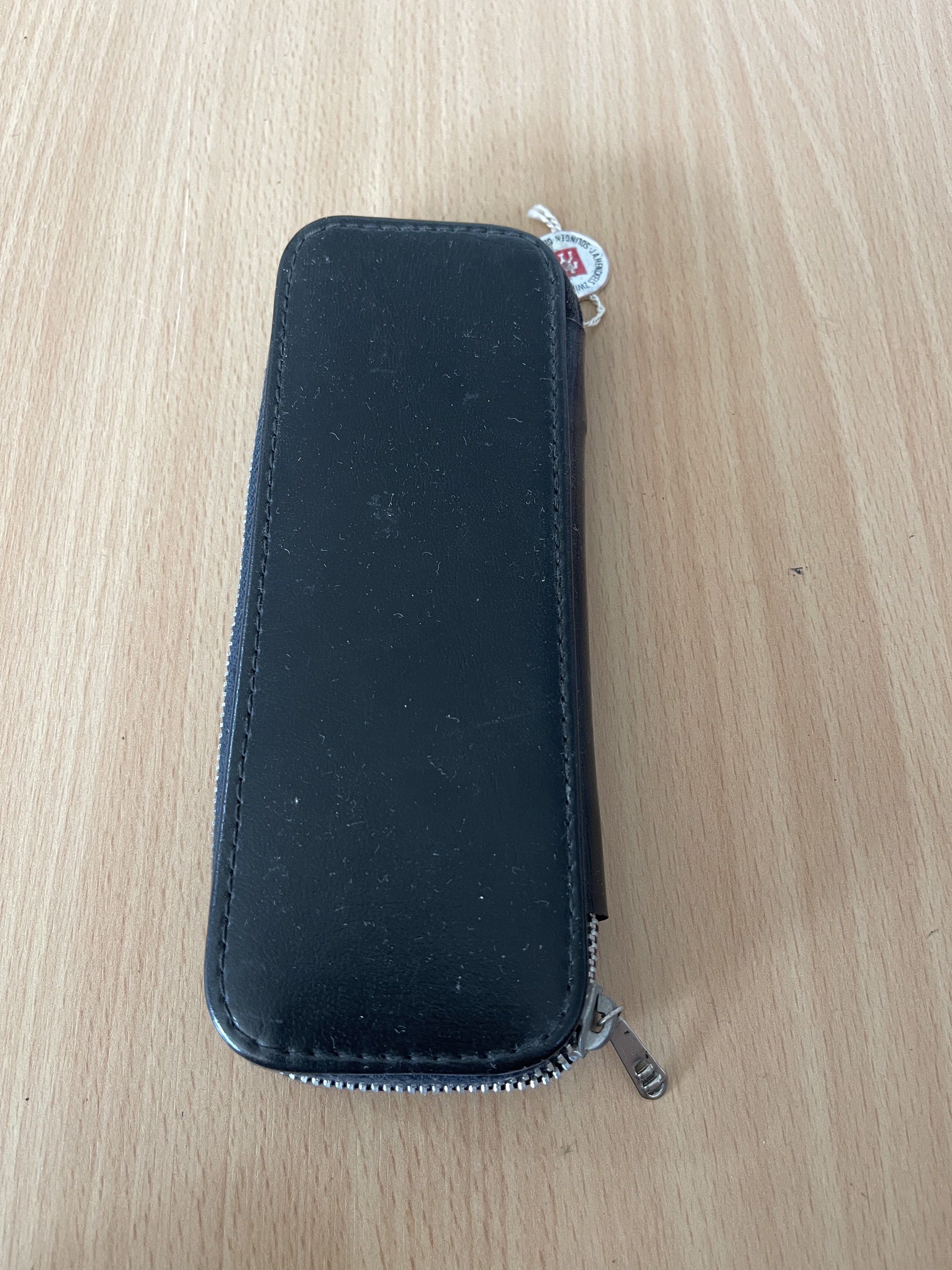 Manicure set (Category: Hands & Nails) located in San Fernando. Submitted by japansurpluselyu (Listing ID 1417022416, Image 2). Description: 1. *Small stainless steel scissors* with black handle grips, positioned on the left side of the pouch. 2. *A pointed nail file or push tool* with a black handle and white tip, placed next to the scissors. 3. *A metal nail clipper* with a white handle, secured in an elastic strap on the right side of the pouc