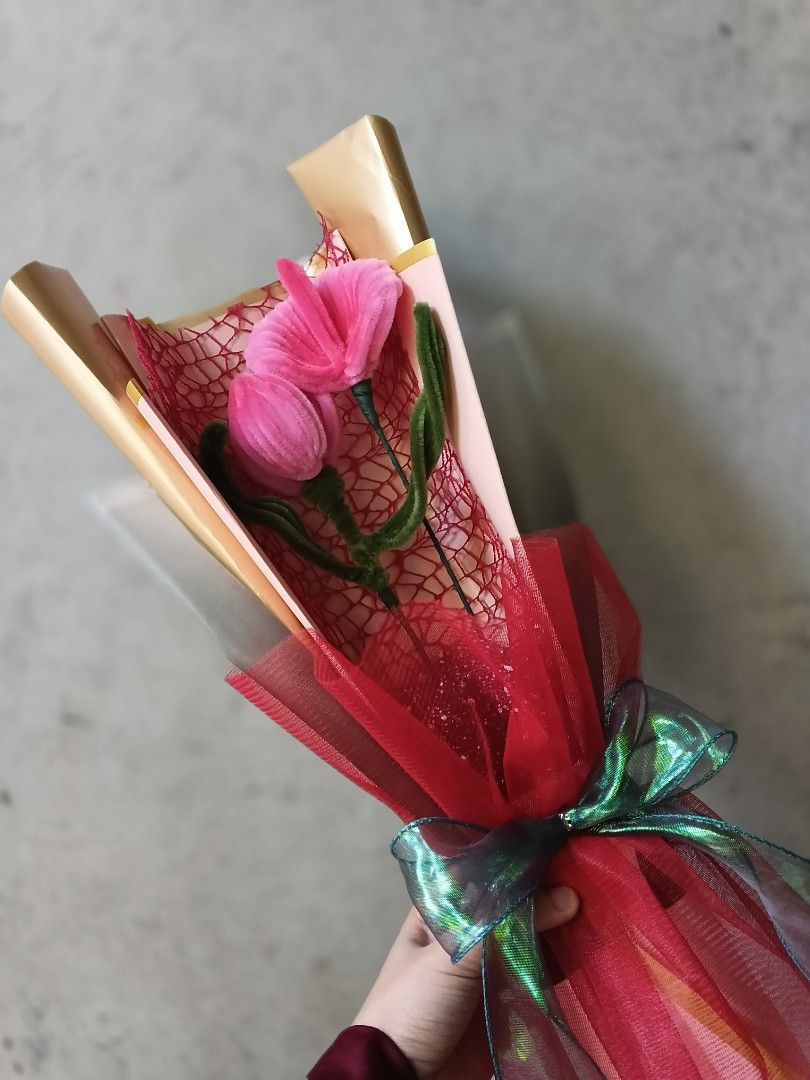 Pink Tulip Bouquet (Category: Flowers & Bouquets) located in Manila. Submitted by mncfuturea99126 (Listing ID 1416948226, Image 1). Description: Beautiful pink tulip bouquet, perfect for gifting or decorating. Features two pink tulips with green stems, wrapped in red mesh and clear cellophane. The bouquet is tied with a green and iridescent ribbon. The wrapping includes gold-colored paper.( 2 flower bouquet) you can choose rose,tulips,Lily, anthu