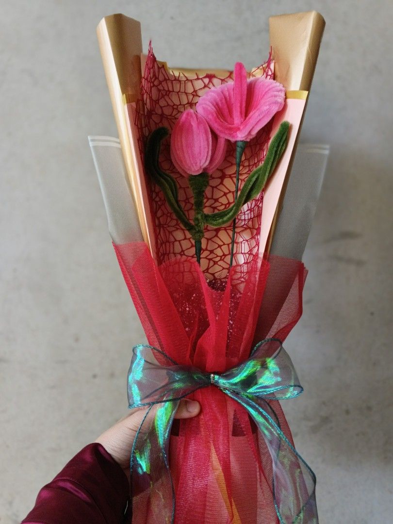 Pink Tulip Bouquet (Category: Flowers & Bouquets) located in Manila. Submitted by mncfuturea99126 (Listing ID 1416948226, Image 2). Description: Beautiful pink tulip bouquet, perfect for gifting or decorating. Features two pink tulips with green stems, wrapped in red mesh and clear cellophane. The bouquet is tied with a green and iridescent ribbon. The wrapping includes gold-colored paper.( 2 flower bouquet) you can choose rose,tulips,Lily, anthu