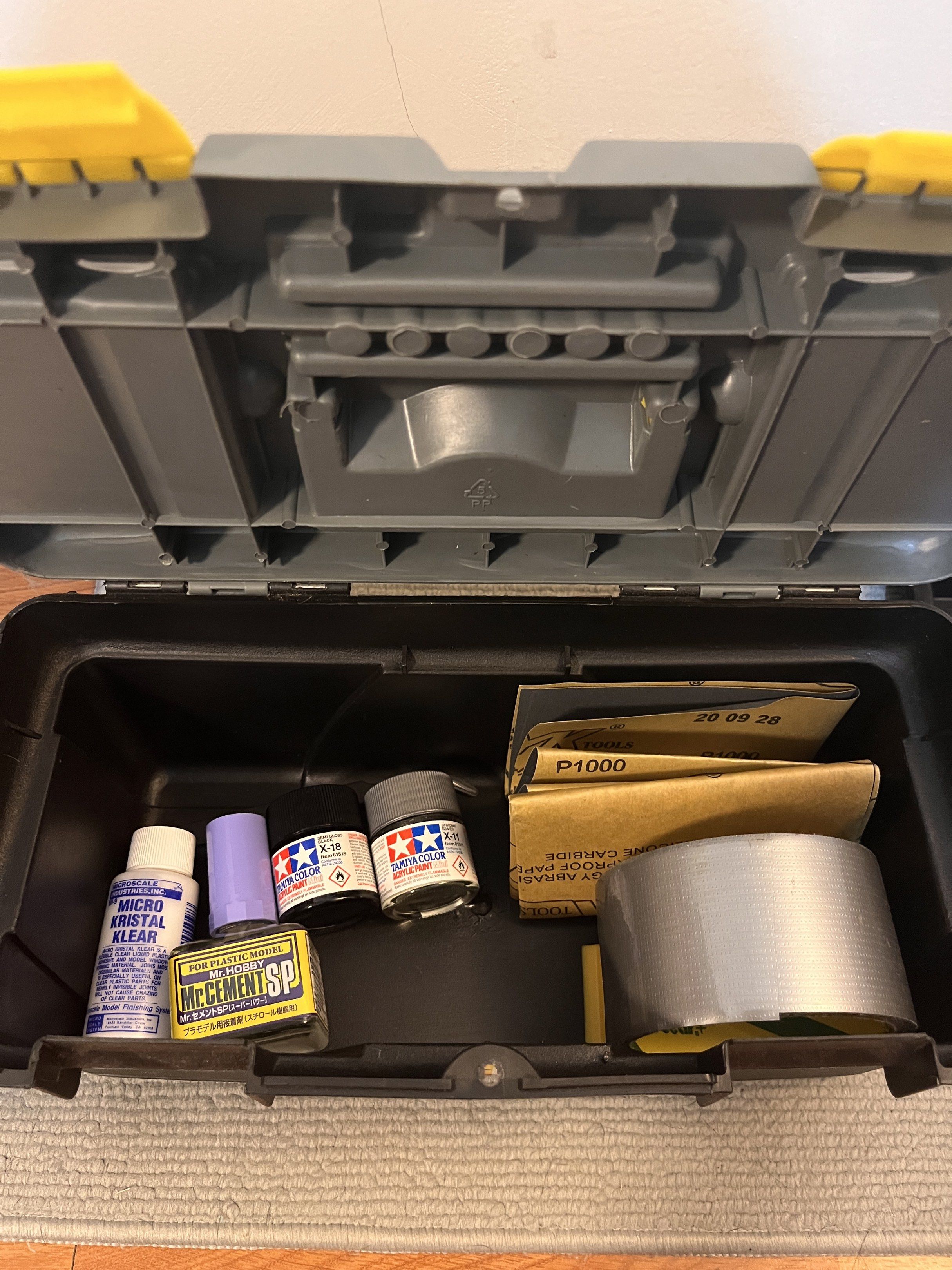 Tamiya Building Toolbox (Category: Craft Supplies & Tools) located in Quezon City. Submitted by fantanaranja (Listing ID 1416948364, Image 1). Description: NEVER BEEN USED includes: - tamiya acrylic paint: semi gloss black and chrome silver - mr. cement plastic cement - micro kristal clear liquid plastic adhesive - 360 and 1000 grit sandpaper - pliers - angled tweezers - screwdriver - tamiya plastic scriber - various filing tools - precision hobb
