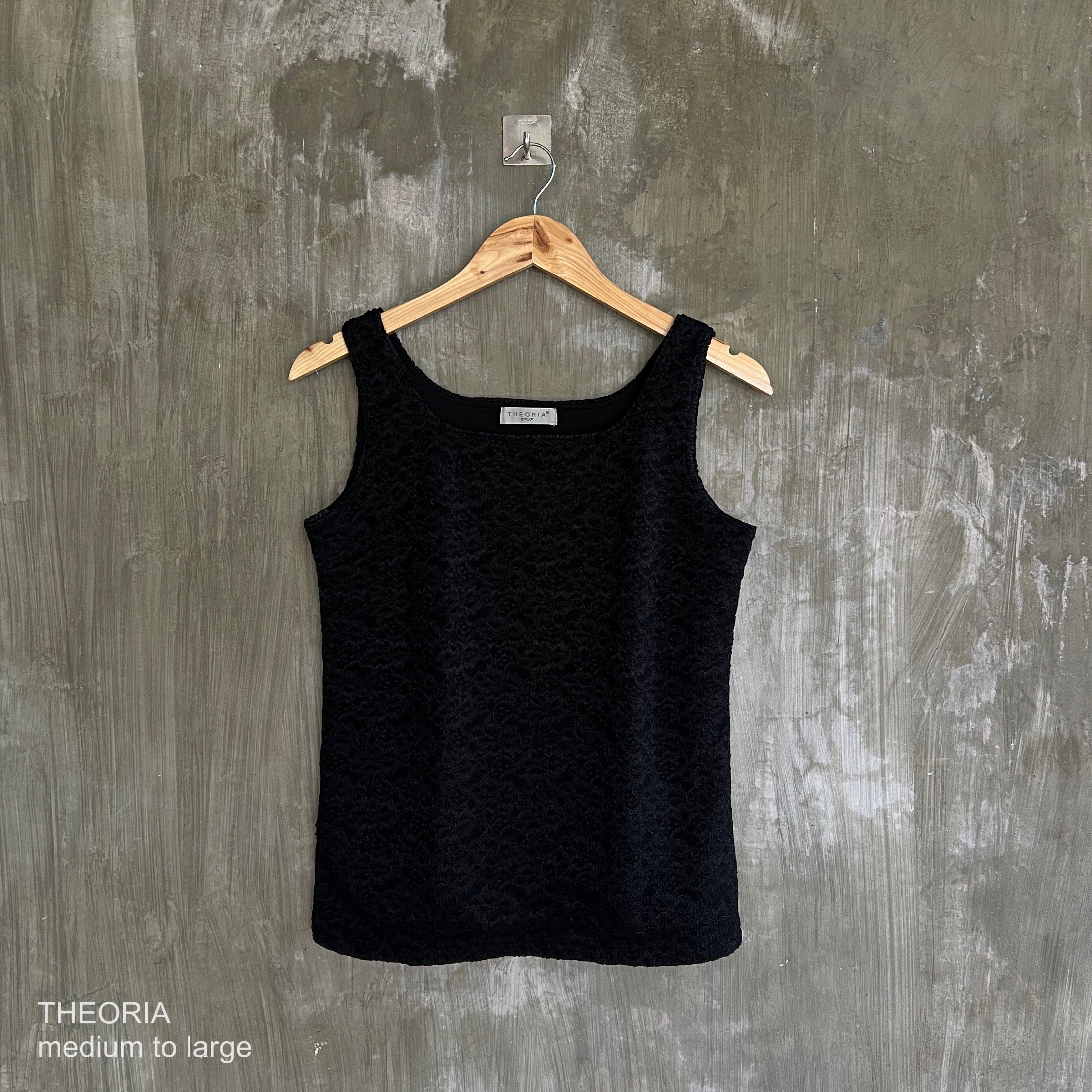Theoria Black Tank Top (Category: Sleeveless) located in Santa Cruz. Submitted by alliyah. (Listing ID 1416917798, Image 1). Description: - Theoria black tank top - Features a textured design - Size: Medium to Large - Versatile for layering or wearing alone.