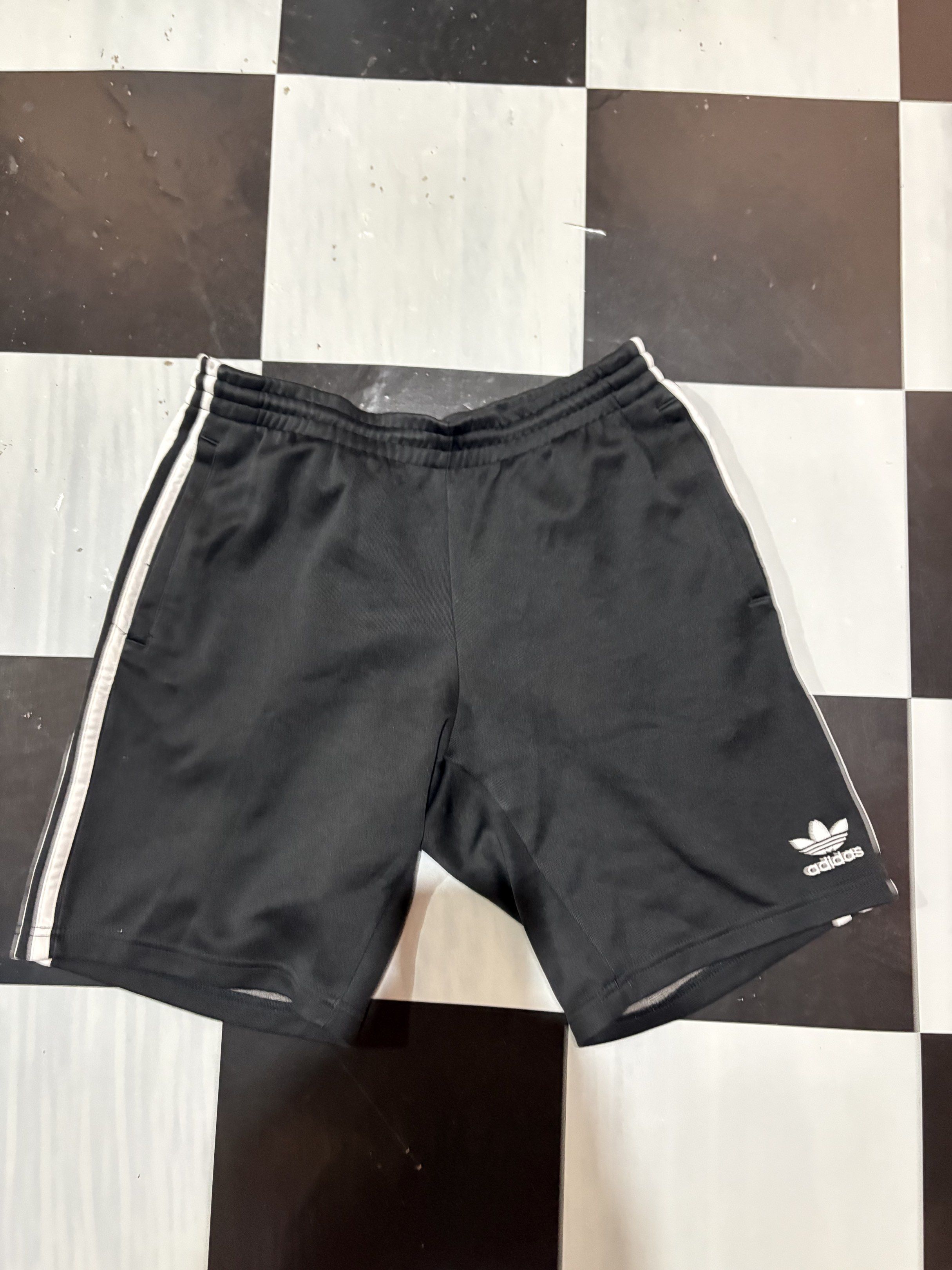 Adidas Shorts with White Stripes (Category: Activewear) located in Cadiz. Submitted by rom96 (Listing ID 1417178942, Image 1). Description: - Adidas black shorts - White stripes on sides - Adidas logo on front - Elastic waistband with drawstring - Sporty fabric - Classic design - Ideal for workouts or casual wear.