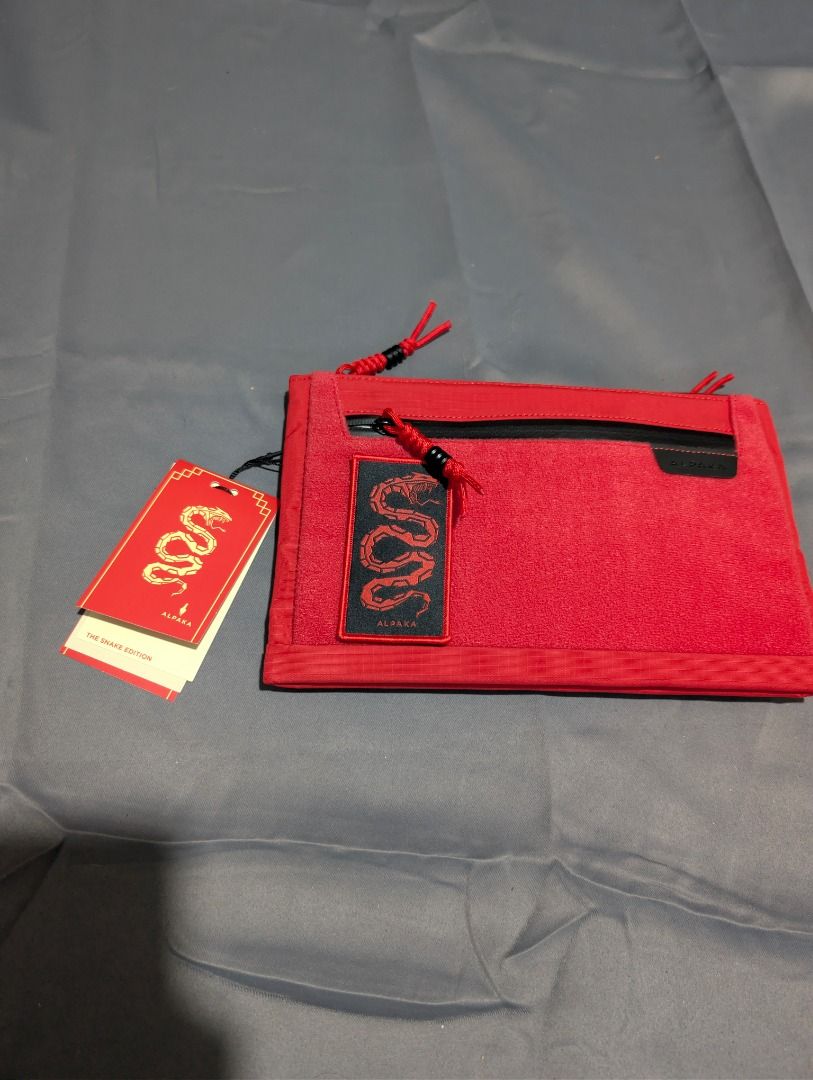 Alpaka Zip Pouch Max - Snake Edition (Category: Belt bags, Clutches and Pouches) located in Quezon City. Submitted by trainforless (Listing ID 1417144236, Image 1). Description: Condition: Never been used Negotiable :) RFS: Decluttering 📦: Lalamove or J&T 💵: GCash, BPI, Seabank Alpaka Zip Pouch Max is a Year of the Snake edition. It features a red exterior with a black zipper and accents. The pouch has multiple compartments inside, including a 