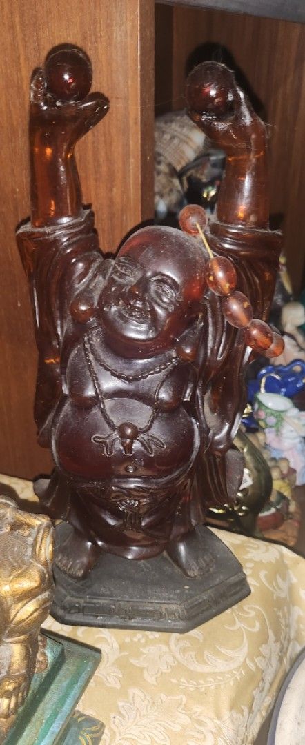 Brown Resin Laughing Buddha Figurine (Category: Other Home Decor) located in Manila. Submitted by maybelle00 (Listing ID 1417065523, Image 1). Description: - 14inches -Laughing Buddha figurine - Made of brown resin - Intricate details - Features a beaded necklace - Holding a sphere - Decorative item for shelf or table.