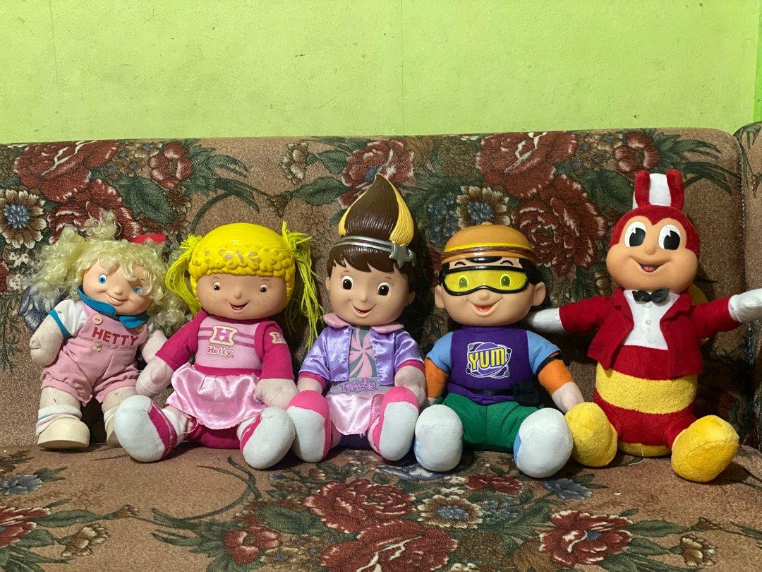 Hetty Doll (Category: Kids Toys) located in Manila. Submitted by kuya_moto (Listing ID 1417038840, Image 3). Description: Hetty doll features a yellow hairstyle and a pink outfit. It has a pink skirt and white shoes. The doll has a small tear on the back. It is part of a collection of dolls, including a Jollibee doll. The doll is in a sitting position..