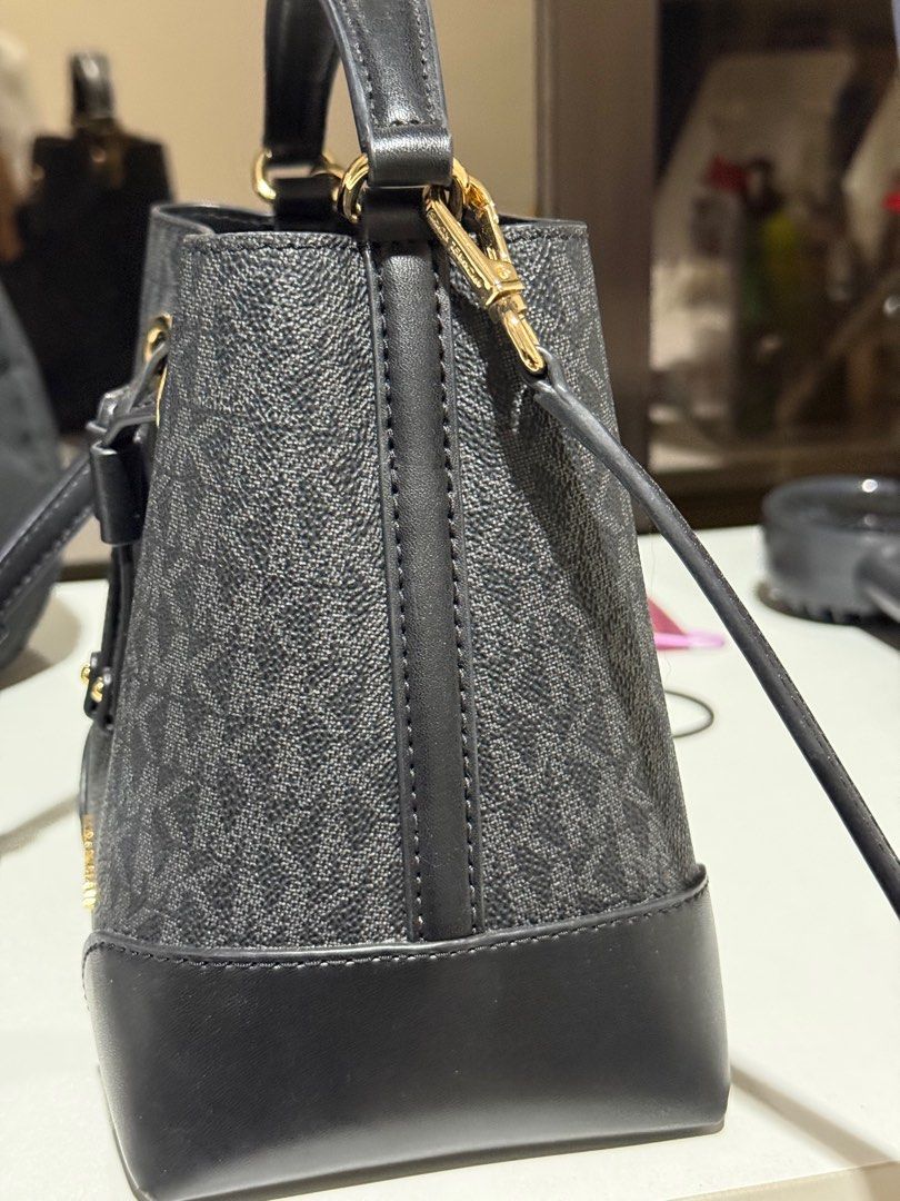Michael Kors Mercer Small Drawstring Bucket Bag (Category: Luxury Bags & Wallets) located in Dasmarinas. Submitted by jc072727 (Listing ID 1417030598, Image 3). Description: Authentic Michael Kors Mercer bucket bag. Features a drawstring closure, top handle, and a detachable crossbody strap. The bag has a black and gray MK logo pattern with black leather accents. Gold-tone hardware is present on the bag. The tag indicates the model number is 35F2