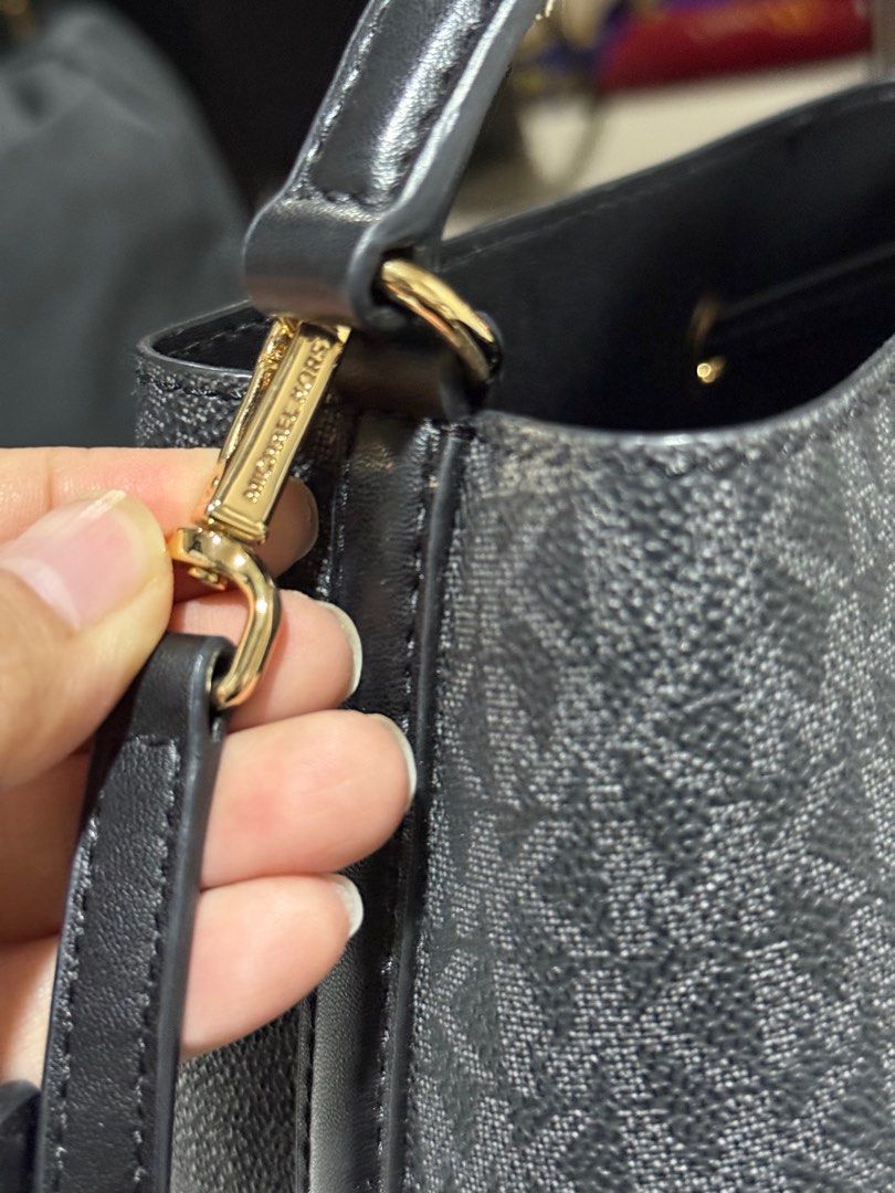 Michael Kors Mercer Small Drawstring Bucket Bag (Category: Luxury Bags & Wallets) located in Dasmarinas. Submitted by jc072727 (Listing ID 1417030598, Image 2). Description: Authentic Michael Kors Mercer bucket bag. Features a drawstring closure, top handle, and a detachable crossbody strap. The bag has a black and gray MK logo pattern with black leather accents. Gold-tone hardware is present on the bag. The tag indicates the model number is 35F2