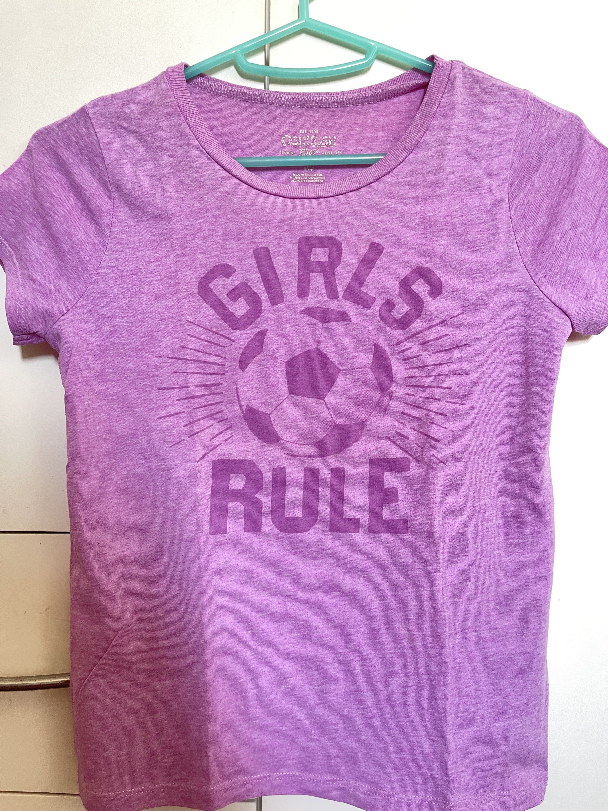 OshKosh - Kids T-shirt (Category: Babies & Kids Fashion) located in Manila. Submitted by closetlibraryph (Listing ID 1417090885, Image 1). Description: - OshKosh Girls Rule soccer graphic - Purple, short-sleeved shirt - Crew neck design - Soft and comfortable fabric - Casual wear appropriate - OshKosh brand visible.