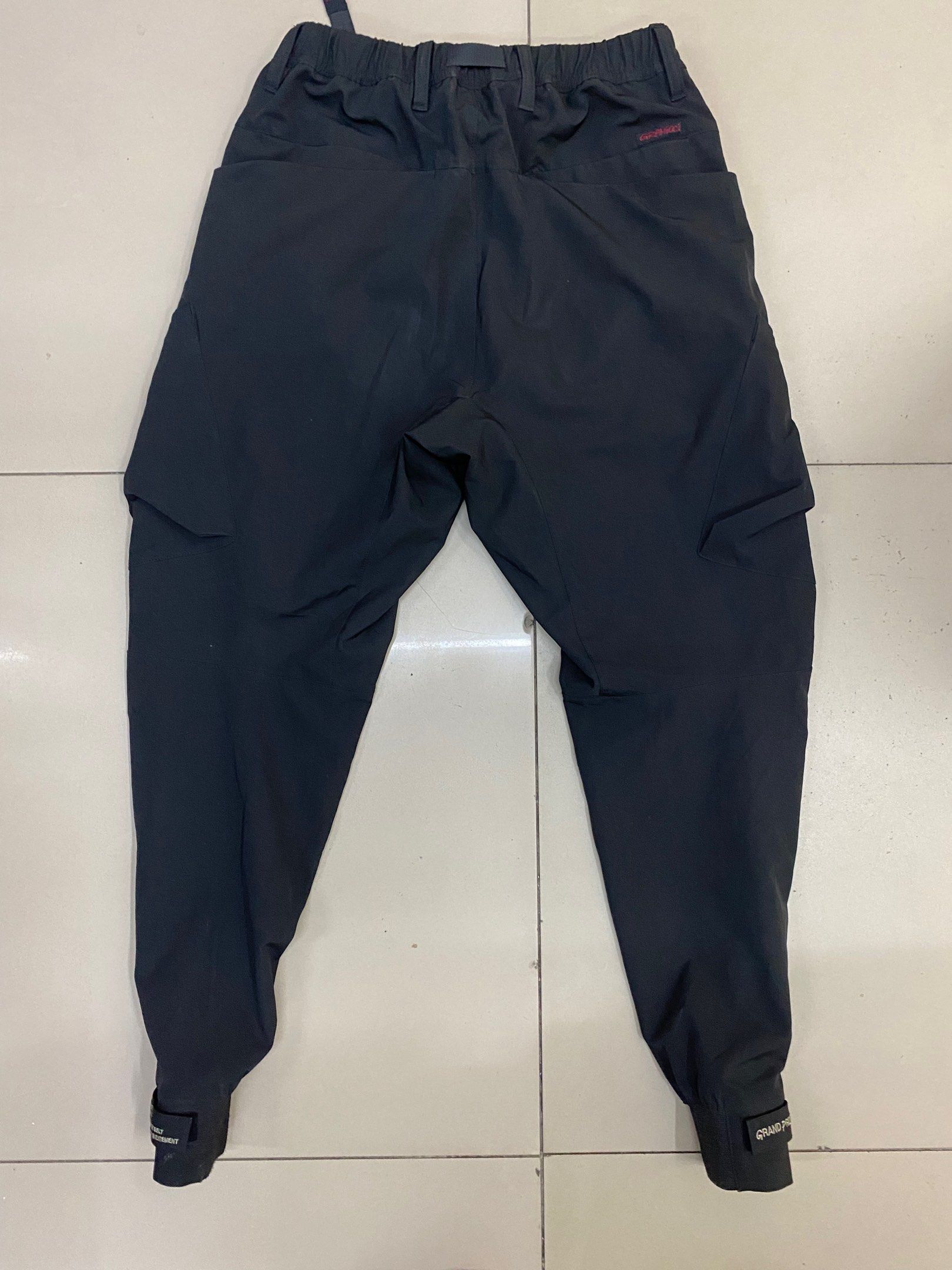 Poliquant x Gramicci GPG Functional Cargo Pants (Category: Trousers) located in Calapan. Submitted by yowstuff (Listing ID 1417068610, Image 2). Description: - Poliquant x Gramicci Black Cargo Pants - Size: Asia S / USA XS - Features: - Built-in belt with buckle - Multiple pockets - Elastic cuffs - Material: Nylon.