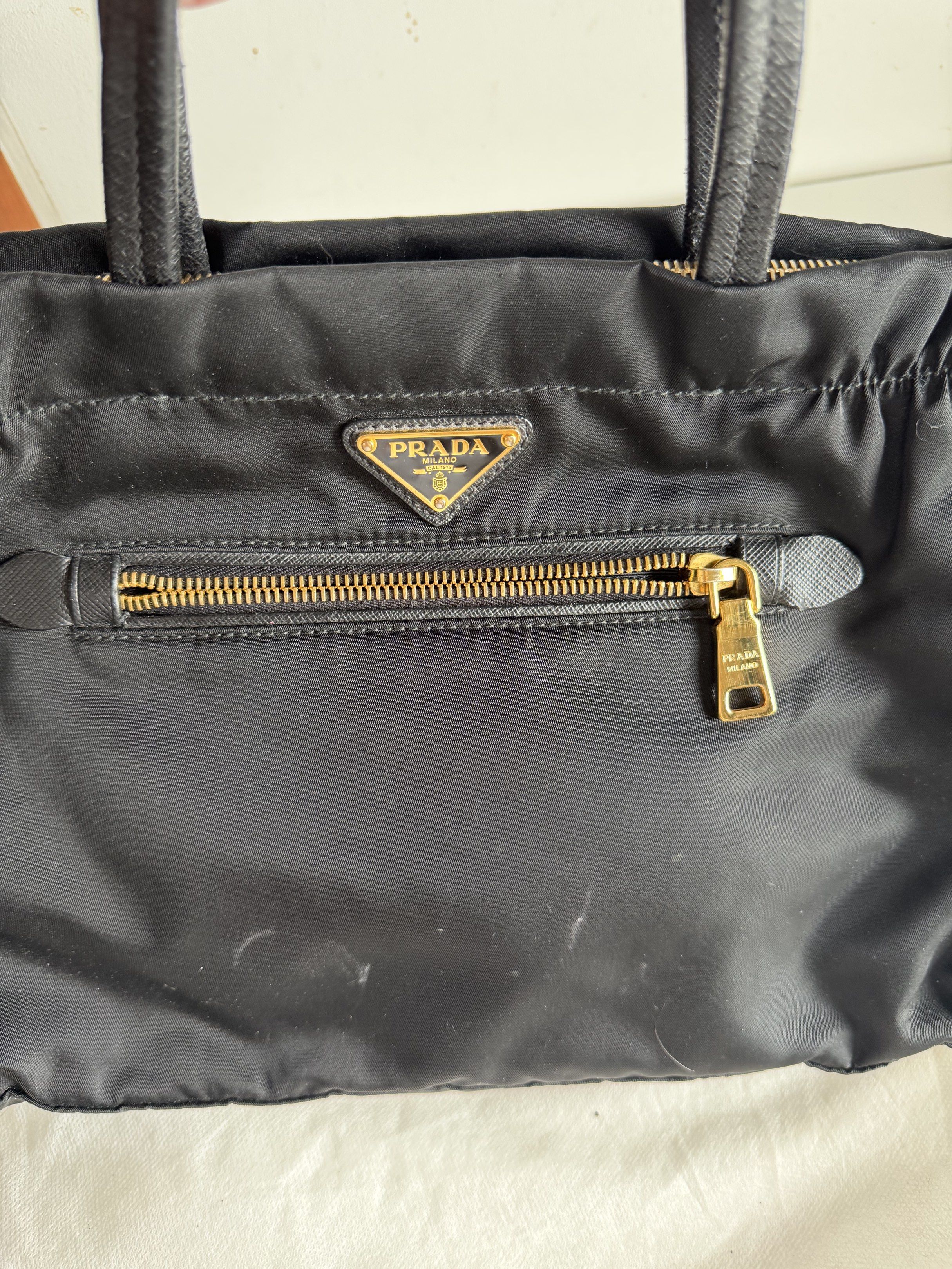 Prada sling bag (Category: Luxury Bags & Wallets) located in Taytay. Submitted by yourhighnessbea (Listing ID 1417134332, Image 2). Description: PRADA TESSUTO 2-WAY BAG Style code: B1843m Color: Black with gold hardware ONLY FLAWS: Handle straps NO CORNER RUBS NO DISCOLORATION GUARANTEED AUTHENTIC WITH ORIGINAL DUST BAGS For reference: https://share.google/images/XvC3Xrc2ZaxFSMgW2 .