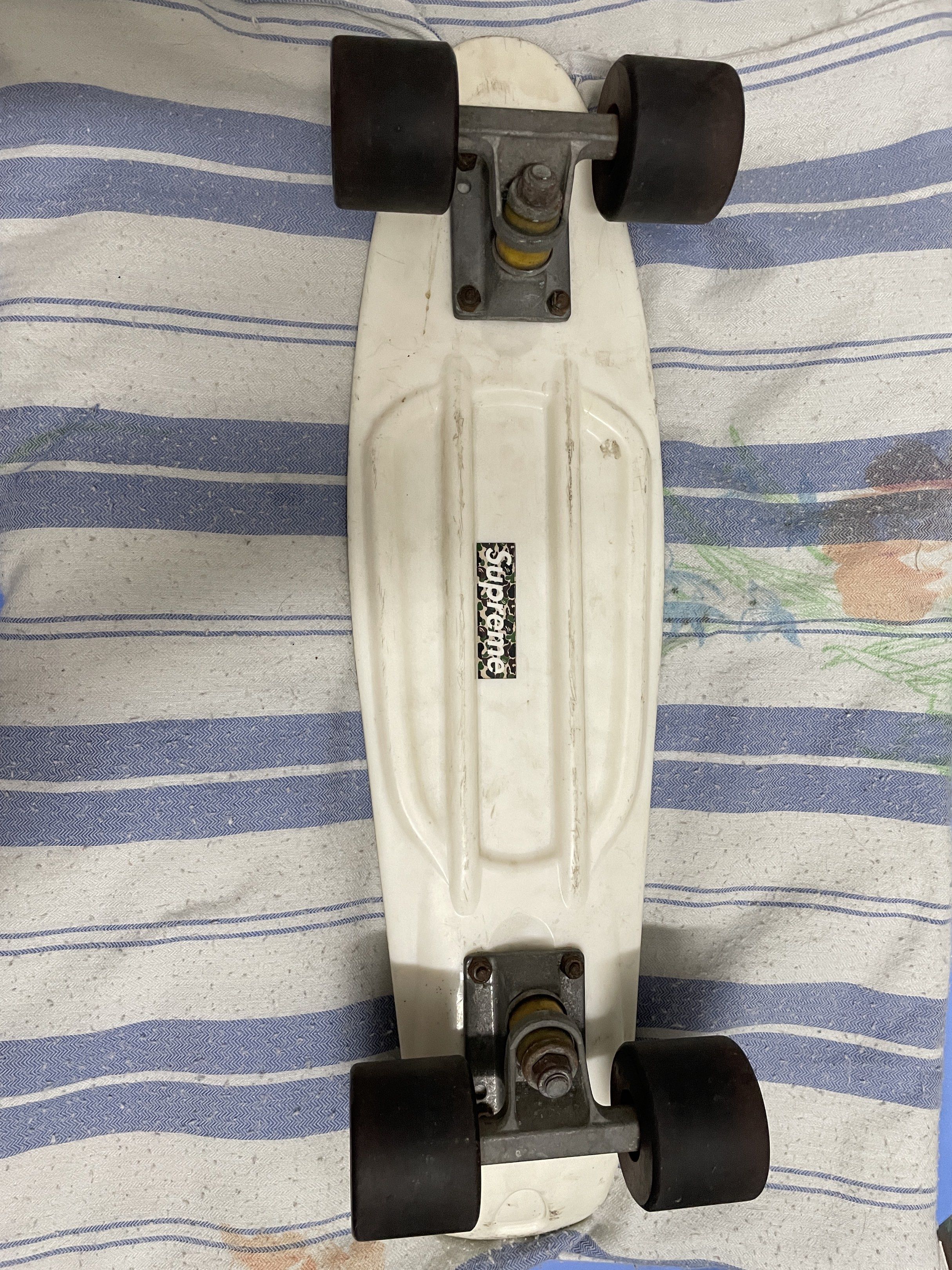 Supreme Penny Board Skateboard (Category: Skates, Rollerblades & Scooters) located in Quezon City. Submitted by 2high2cry. (Listing ID 1417104627, Image 2). Description: - Sup Penny board skateboard - Lavender jelly wheels - Silver trucks - Diamond grip deck - Supreme logo sticker on underside - Wheels show wear - Standard size.