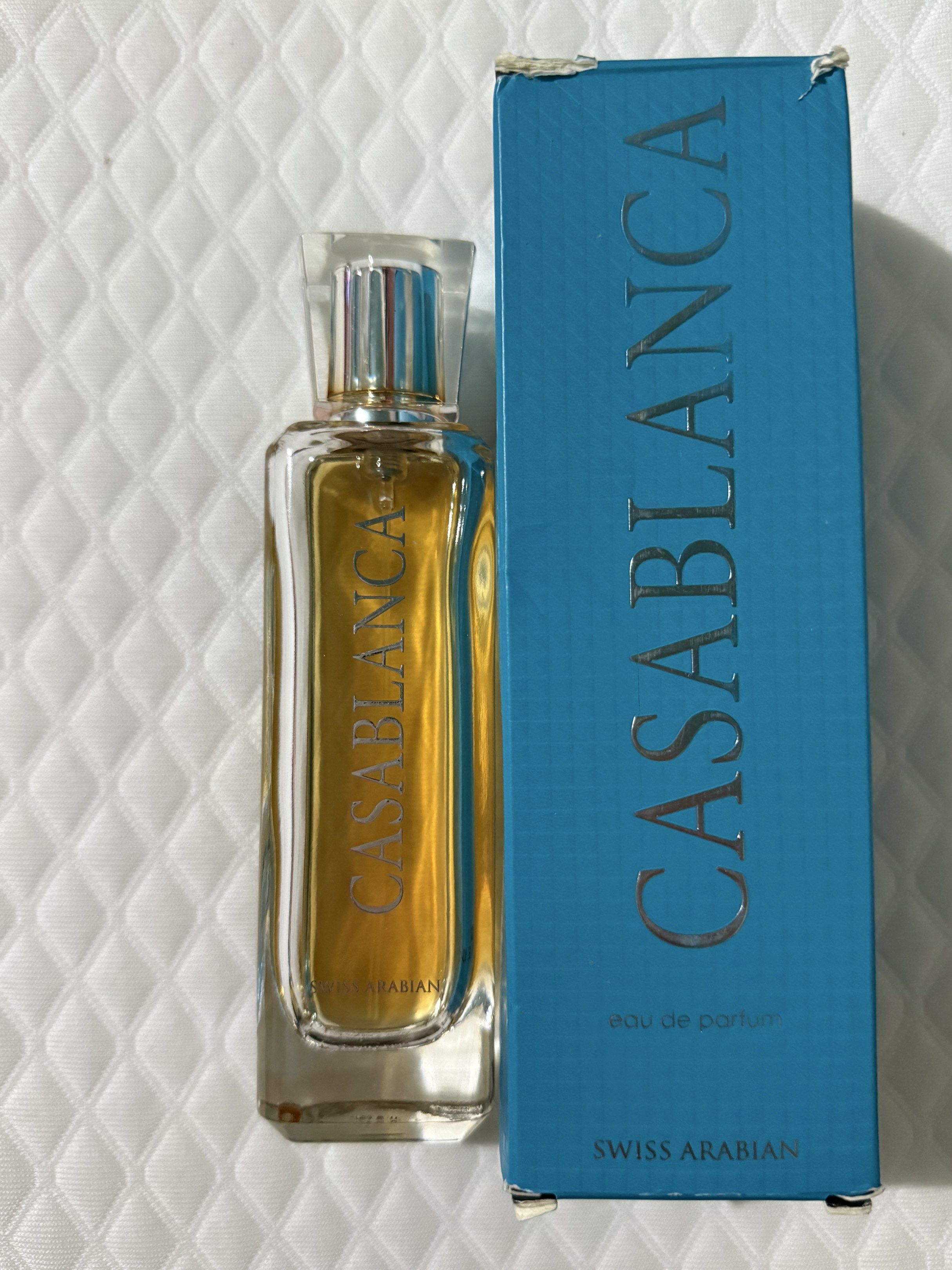 Swiss Arabian Casablanca Eau de Parfum (Category: Fragrance & Deodorants) located in Tarlac. Submitted by yoona88 (Listing ID 1417035948, Image 1). Description: - Swiss Arabian Casablanca Eau de Parfum - Includes original blue box with silver lettering - Rectangular perfume bottle with clear cap - Golden-colored perfume liquid - Brand name printed on the bottle - Half full.