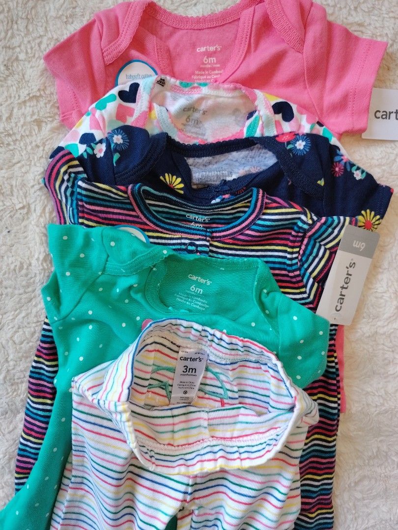 Bundle Clothes for Baby Girl (Category: Babies & Kids Fashion) located in Makati City. Submitted by Prettykids (Listing ID 1417377758, Image 2). Description: Brandnew Carter's onesies With 1 romper and 1 pants Adorable Carter's baby clothes set. Includes a striped dress, several short-sleeved tops, a onesie, and striped pants. The set features various colors and patterns, including hearts, flowers, and polka dots. Some items have tags attached. S