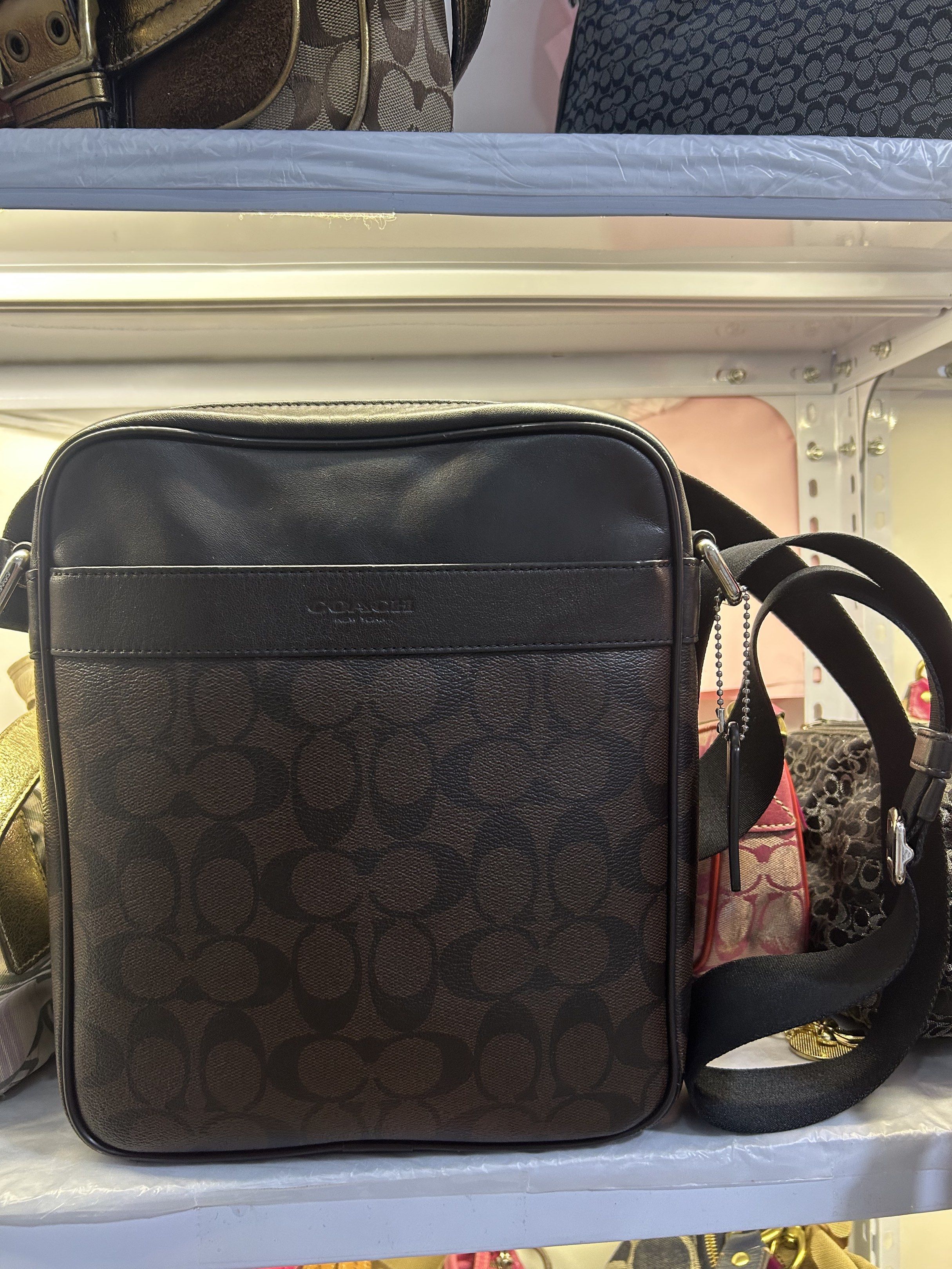 Coach Signature Messenger Bag (Category: Luxury Bags & Wallets) located in Manila. Submitted by graceyabut0 (Listing ID 1417220181, Image 2). Description: Coach messenger bag features the signature brown pattern with a black adjustable strap. It has a zip closure and a front pocket. The interior includes a slip pocket and a Coach label. The bag is made of leather and has a rectangular shape. The bag has a silver-tone hardware..