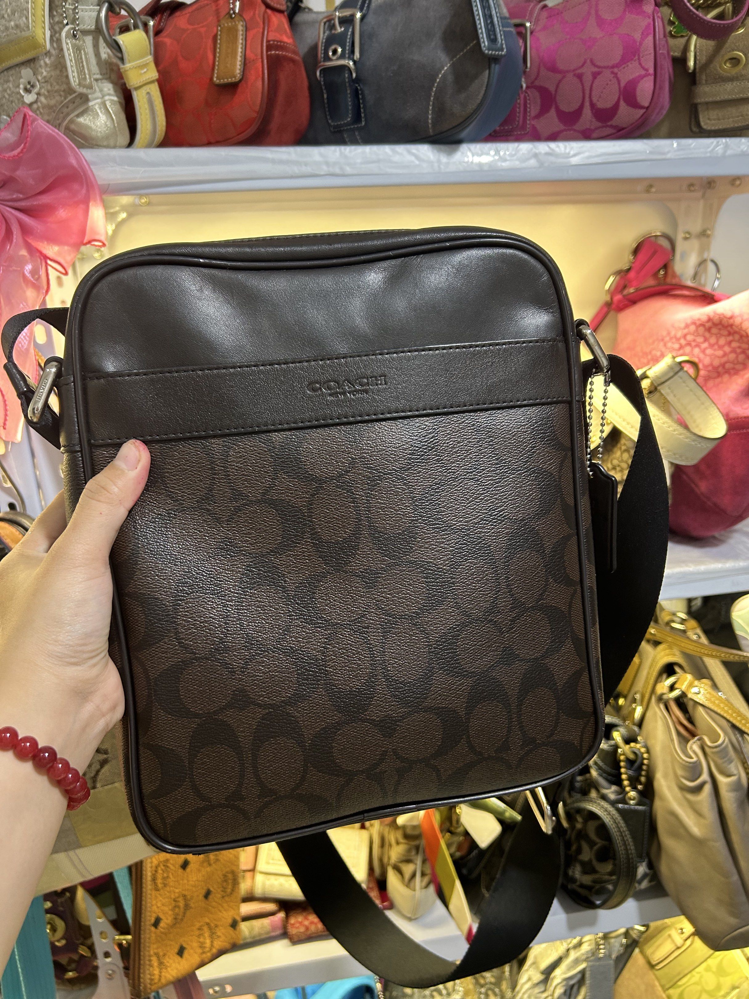 Coach Signature Messenger Bag (Category: Luxury Bags & Wallets) located in Manila. Submitted by graceyabut0 (Listing ID 1417220181, Image 3). Description: Coach messenger bag features the signature brown pattern with a black adjustable strap. It has a zip closure and a front pocket. The interior includes a slip pocket and a Coach label. The bag is made of leather and has a rectangular shape. The bag has a silver-tone hardware..