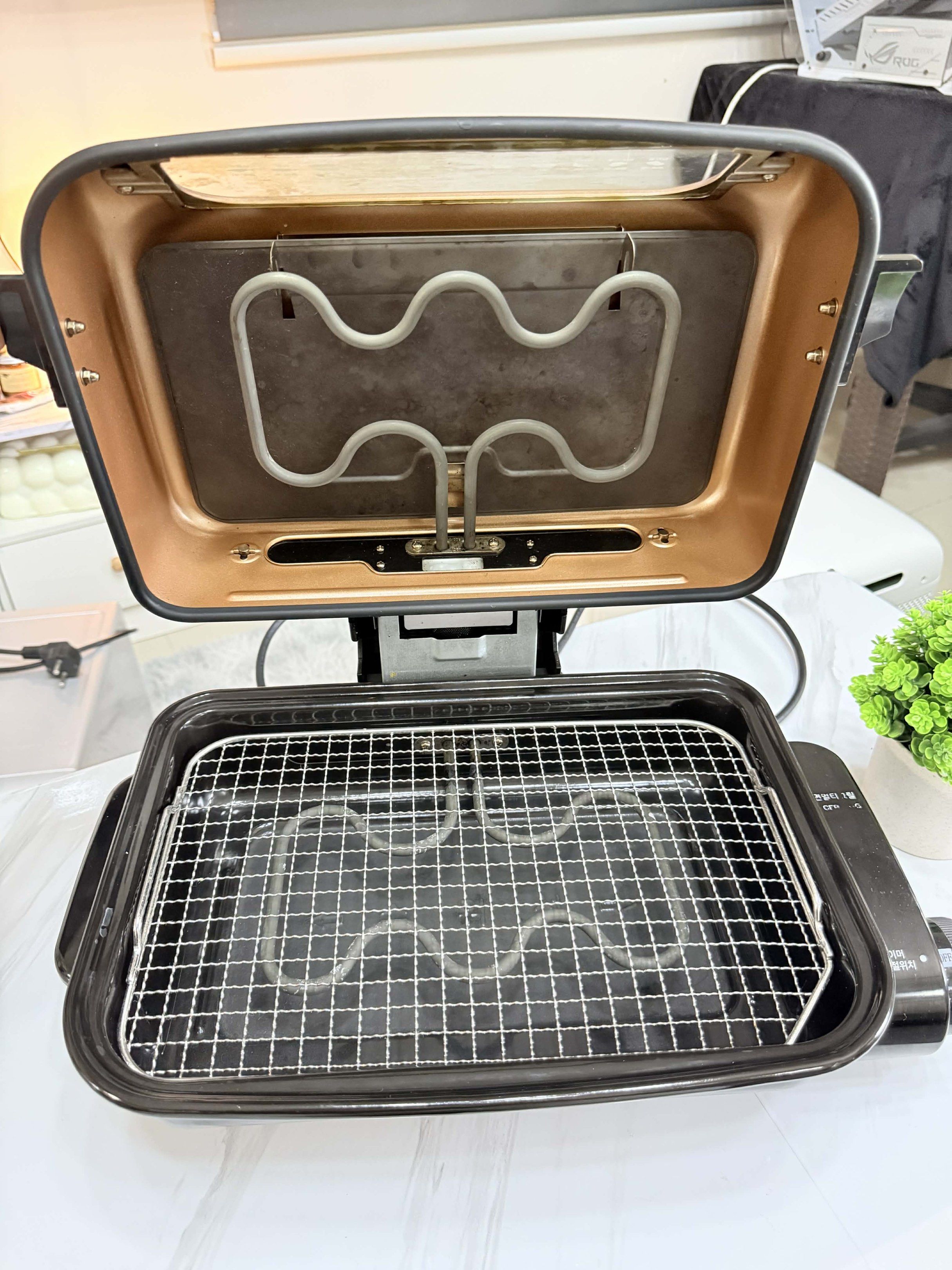 Cuckoo Electric Grill (Category: BBQ, Grills & Hotpots) located in Manila. Submitted by zenwolf-d484b8 (Listing ID 1417271539, Image 2). Description: - Copper-colored exterior - Black cooking surface - Visible heating element - Temperature control dial - Includes wire rack - Transparent viewing window - Designed for various cooking functions.