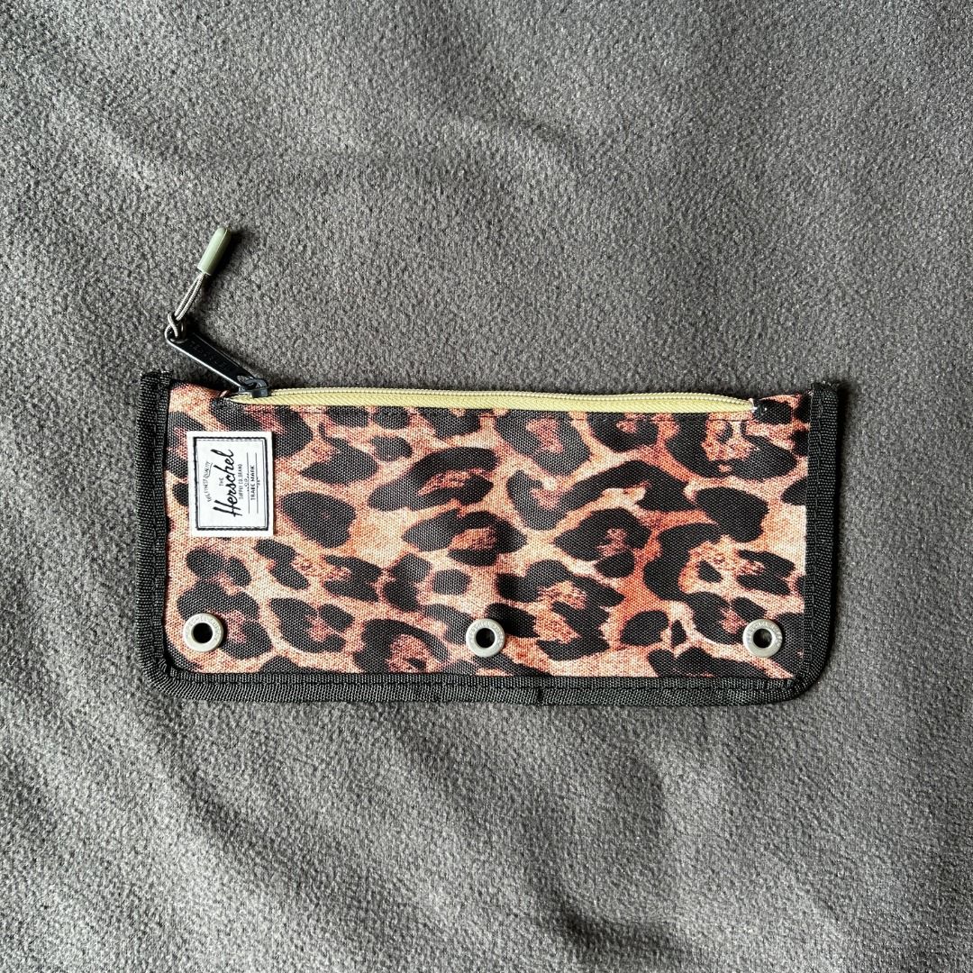 Herschel Pouch/Pencil Case Leopard Print (Category: Cases & Sleeves) located in Manila. Submitted by nyahngr15 (Listing ID 1417295594, Image 1). Description: - Leopard print design - Zipper closure - Black trim - Herschel logo on front - Three metal eyelets - Beige interior zipper.