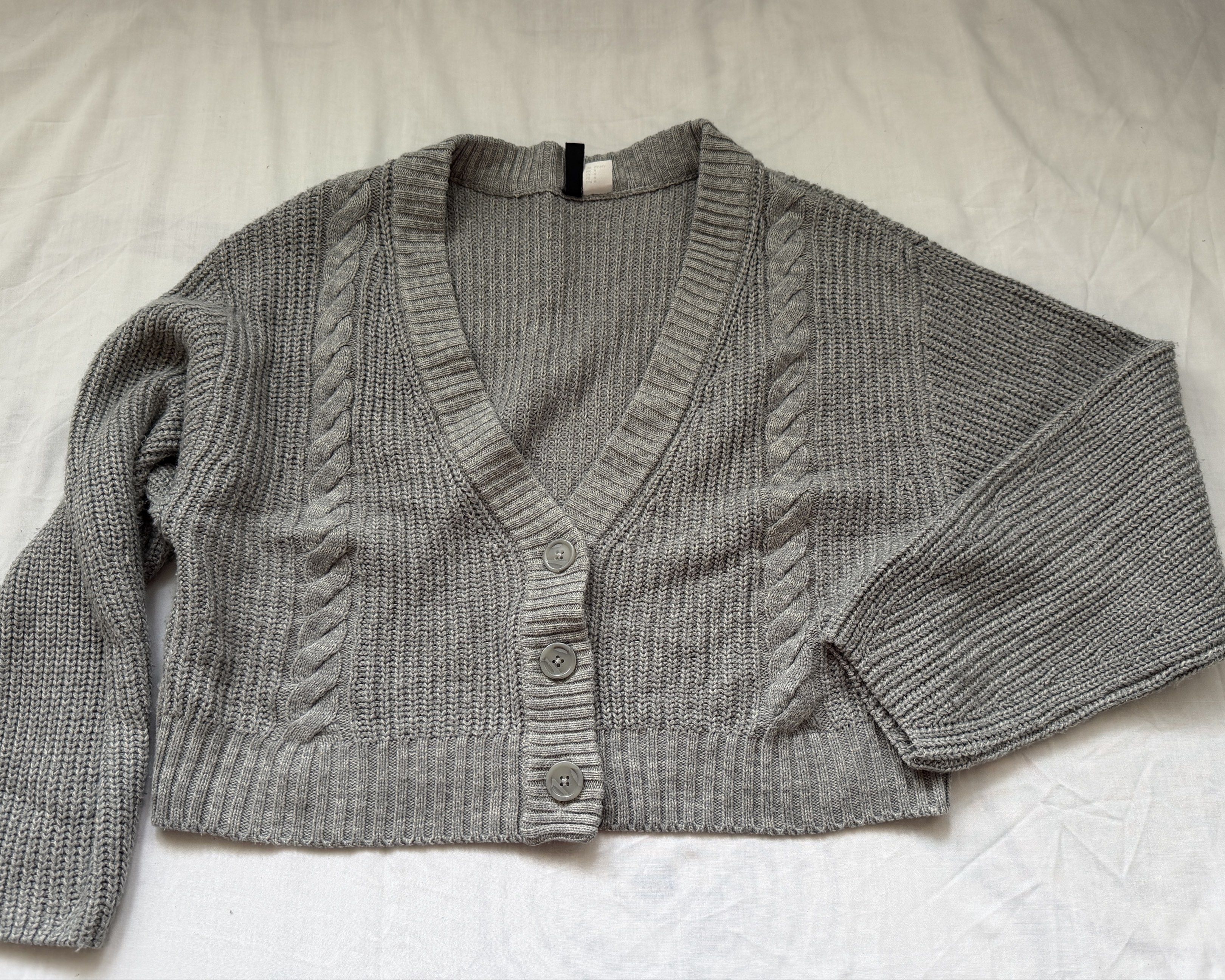 H&M Divided Gray Knit Cardigan (Category: Coats, Jackets and Outerwear) located in Cavite. Submitted by grazielaa (Listing ID 1417289146, Image 2). Description: - H&M Divided gray knit cardigan - Size: M - Features a V-neck - Button closure - Cable knit detailing on sleeves - Long sleeves - Cropped length - Ribbed knit material RFS: decluttering MOP: Gcash & BDO Don’t hesitate to message me if you have any questions .