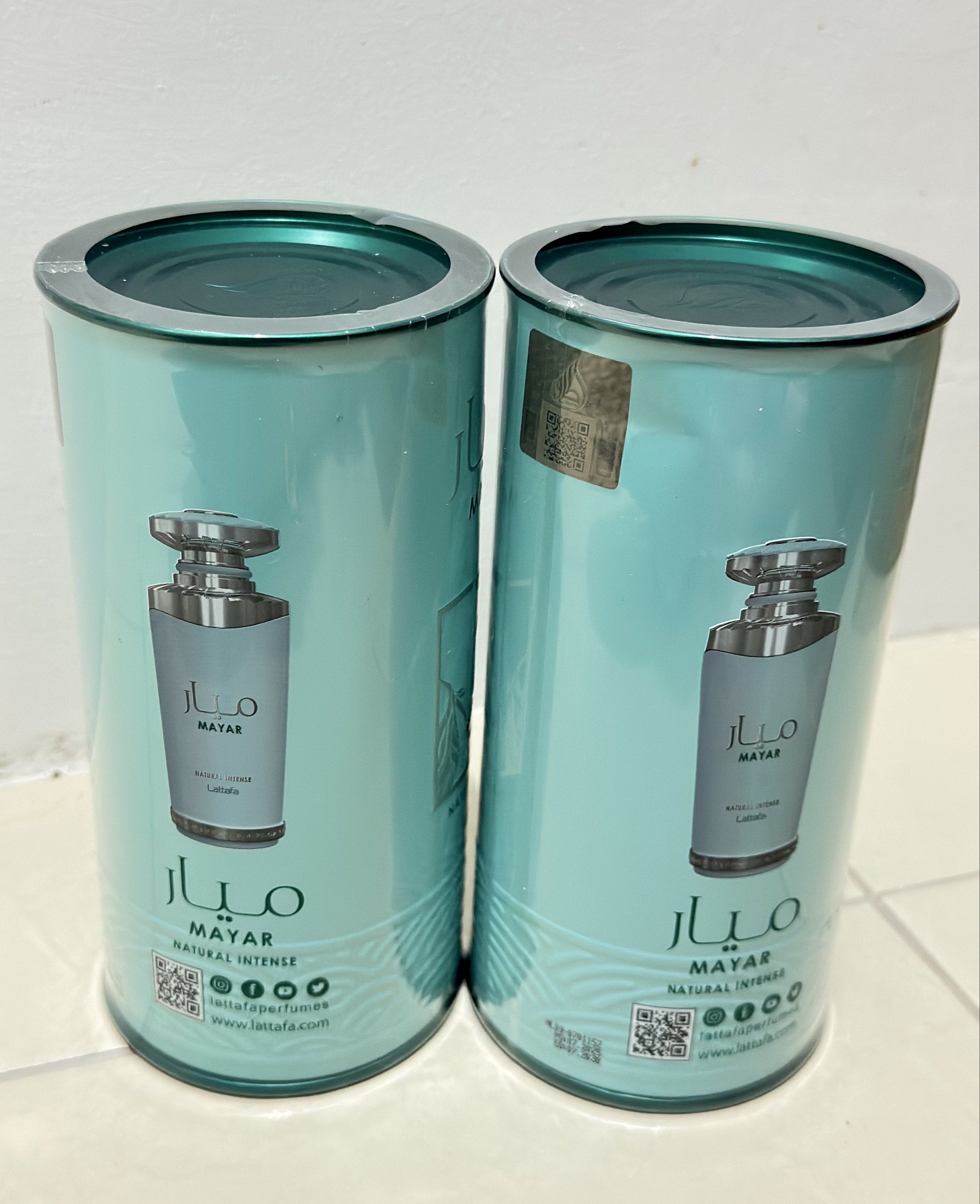 Lattafa Mayar Natural Intense Perfume (Category: Fragrance & Deodorants) located in General Mariano Alvarez. Submitted by donnabeys (Listing ID 1417248389, Image 2). Description: - Two bottles of Lattafa Mayar Natural Intense perfume. - Cylindrical bottles with a teal and gold design. - Authentic Lattafa product. - Each bottle includes a cap and label. - Packaging clearly displays the brand name and "Natural Intense"..