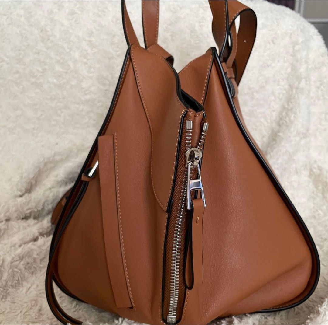Loewe Hammock in Tan Small (Category: Luxury Bags & Wallets) located in Muntinlupa City. Submitted by manikascloset (Listing ID 1417309481, Image 2). Description: - Authentic Loewe Puzzle Bag - Stunning tan color - Unique geometric design - Secure zip closure - Includes a detachable shoulder strap - Comfortable top handles for hand carry - Spacious interior for daily essentials - Features the iconic Loewe logo - Ideal for everyday use.