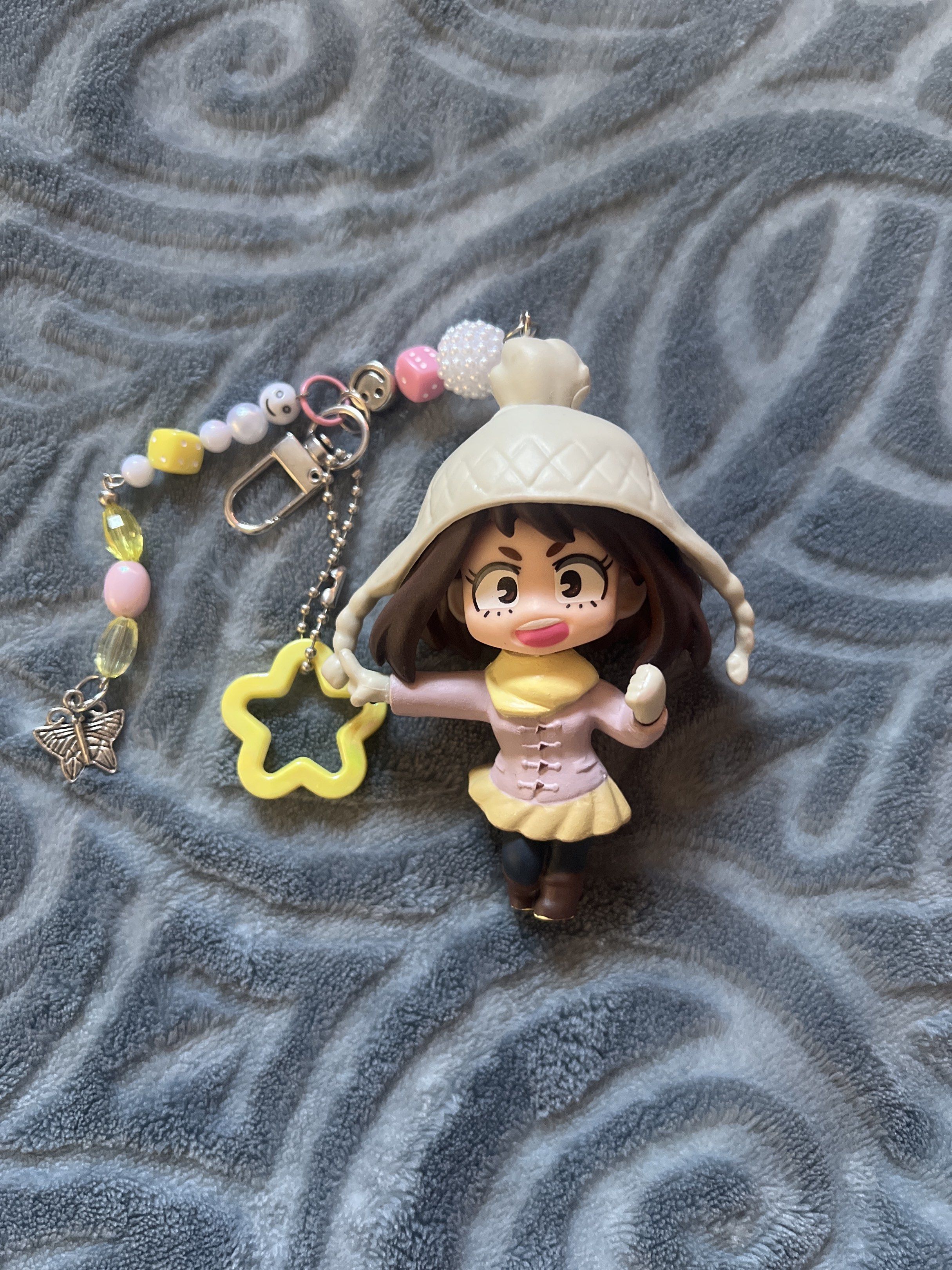My Hero Academia Uraraka Keychain (Category: Character Goods) located in Manila. Submitted by chocoboruur (Listing ID 1417290286, Image 1). Description: - Adorable Uraraka keychain with a chibi design. - Features a star charm and a butterfly charm. - Decorated with colorful beads and a smiley face bead. - Perfect for anime fans and bag decoration..