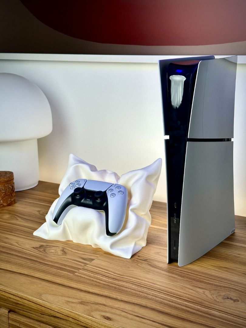 PlayStation 5 Controller Pillow Stand | Soft‑Style Display Base | Aesthetic PS5 Desk Decor (Category: Controllers) located in Mandaluyong City. Submitted by heyitslaaaance (Listing ID 1417219128, Image 2). Description: Give your PS5 controller the premium display it deserves with this PlayStation 5 Controller Pillow Stand — a stylish, unique centerpiece for any gaming setup. Designed to look like a luxurious soft pillow (but actually made from st