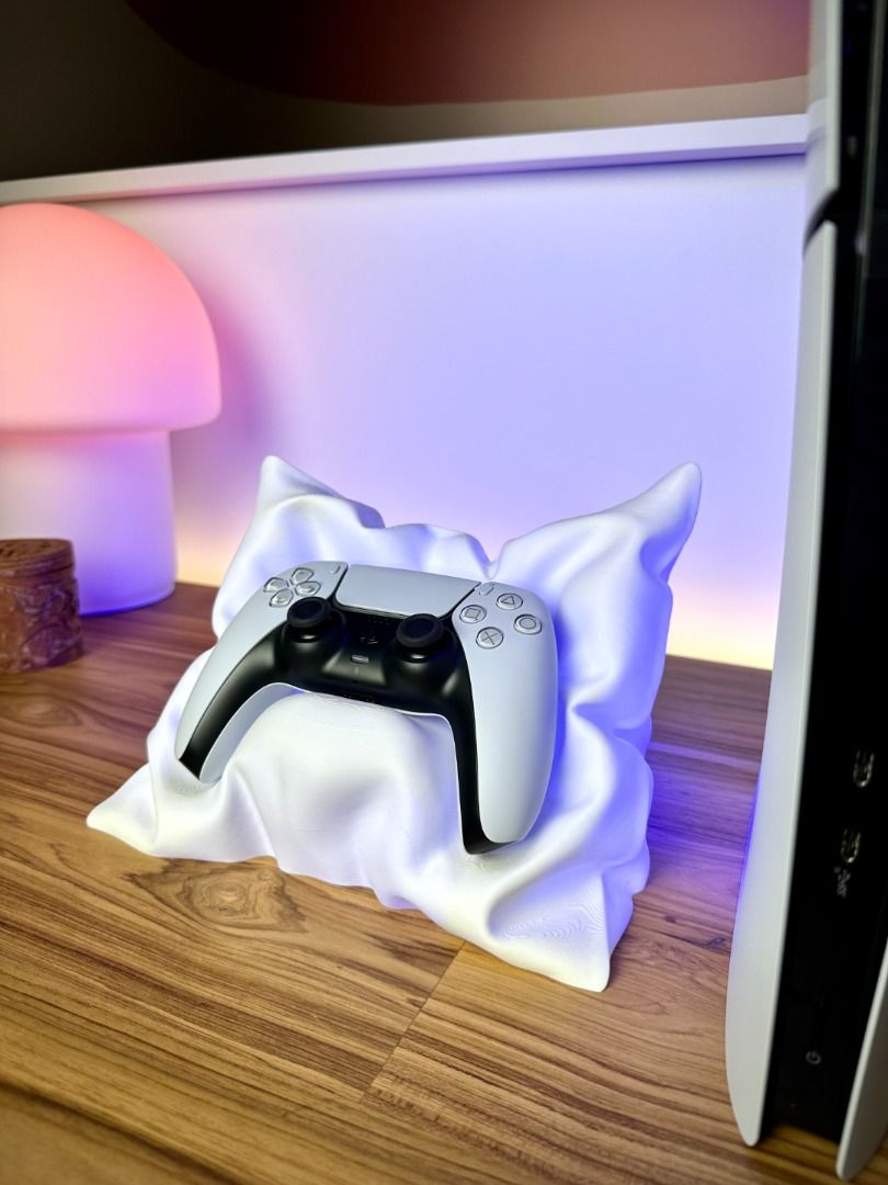 PlayStation 5 Controller Pillow Stand | Soft‑Style Display Base | Aesthetic PS5 Desk Decor (Category: Controllers) located in Mandaluyong City. Submitted by heyitslaaaance (Listing ID 1417219128, Image 3). Description: Give your PS5 controller the premium display it deserves with this PlayStation 5 Controller Pillow Stand — a stylish, unique centerpiece for any gaming setup. Designed to look like a luxurious soft pillow (but actually made from st