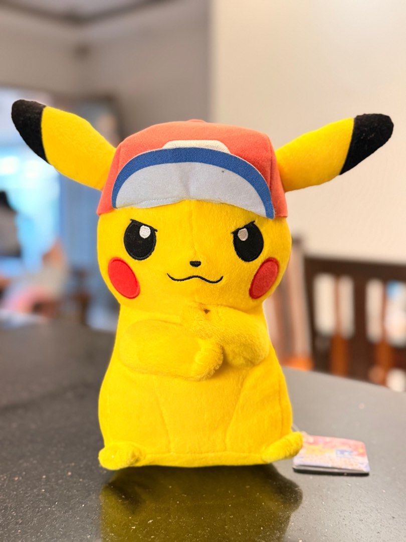 Pokemon Pikachu Plush Ash Cap (Category: Plushies & Soft Toys) located in Paranaque City. Submitted by thirdys_locker (Listing ID 1417314797, Image 1). Description: - Authentic Pikachu plush toy - Features a red cap with white and blue brim - Approximately 25cm tall - Includes Crane King and Banpresto tag - Tag features Pikachu and Ash - Yellow plush with black ears and red cheeks.